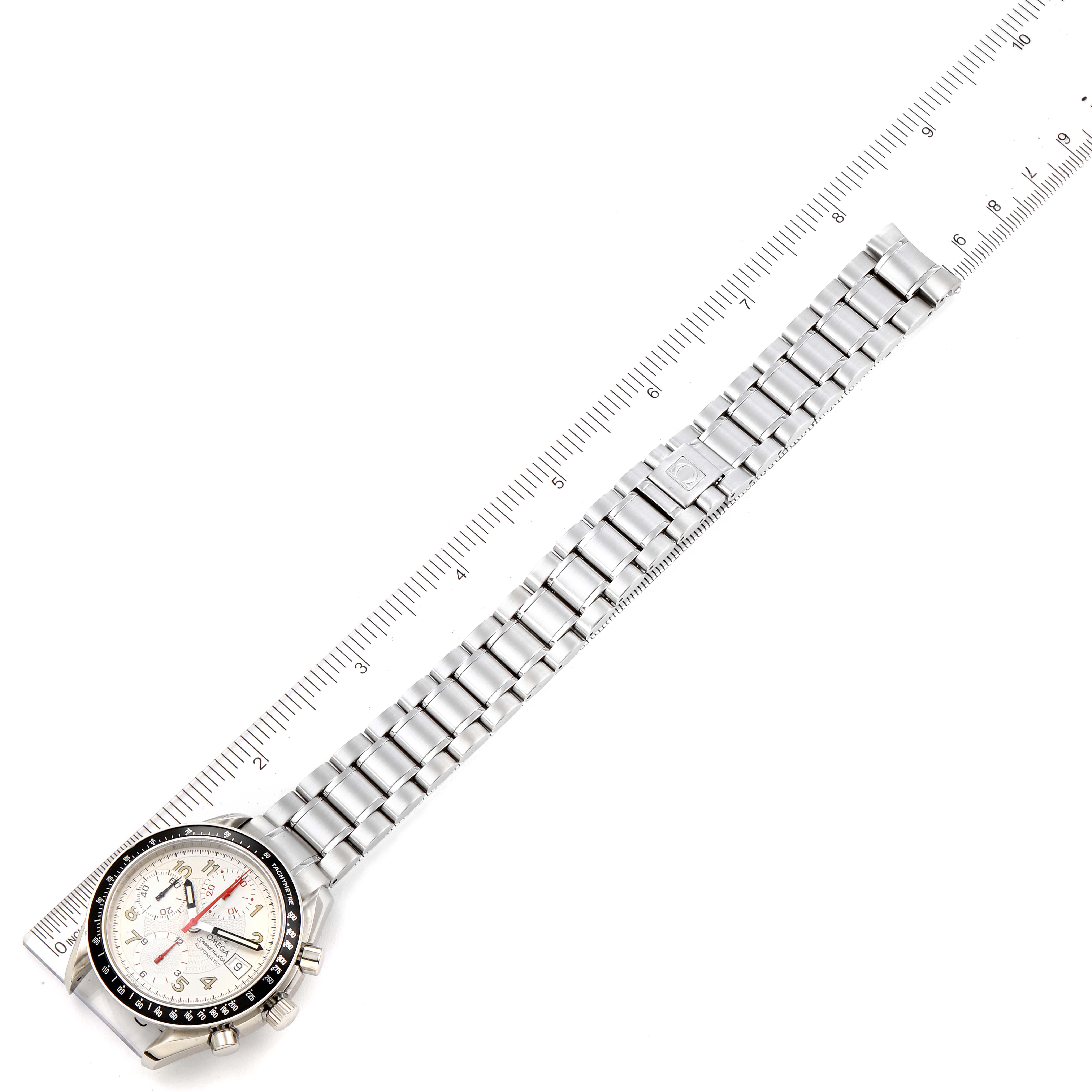 This is an overhead view of an Omega Speedmaster 3513.33.00 Men
s Stainless Steel White Dial 3513.33.00 Men
s Stainless Steel White Dial watch, showcasing its full length including the dial and metal bracelet against a ruler.