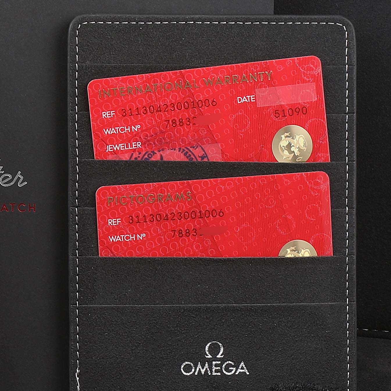 The image shows the warranty cards and holder for the Omega Speedmaster 311.30.42.30.01.006 Men
s Stainless Steel Black Dial 311.30.42.30.01.006 Men
s Stainless Steel Black Dial watch.