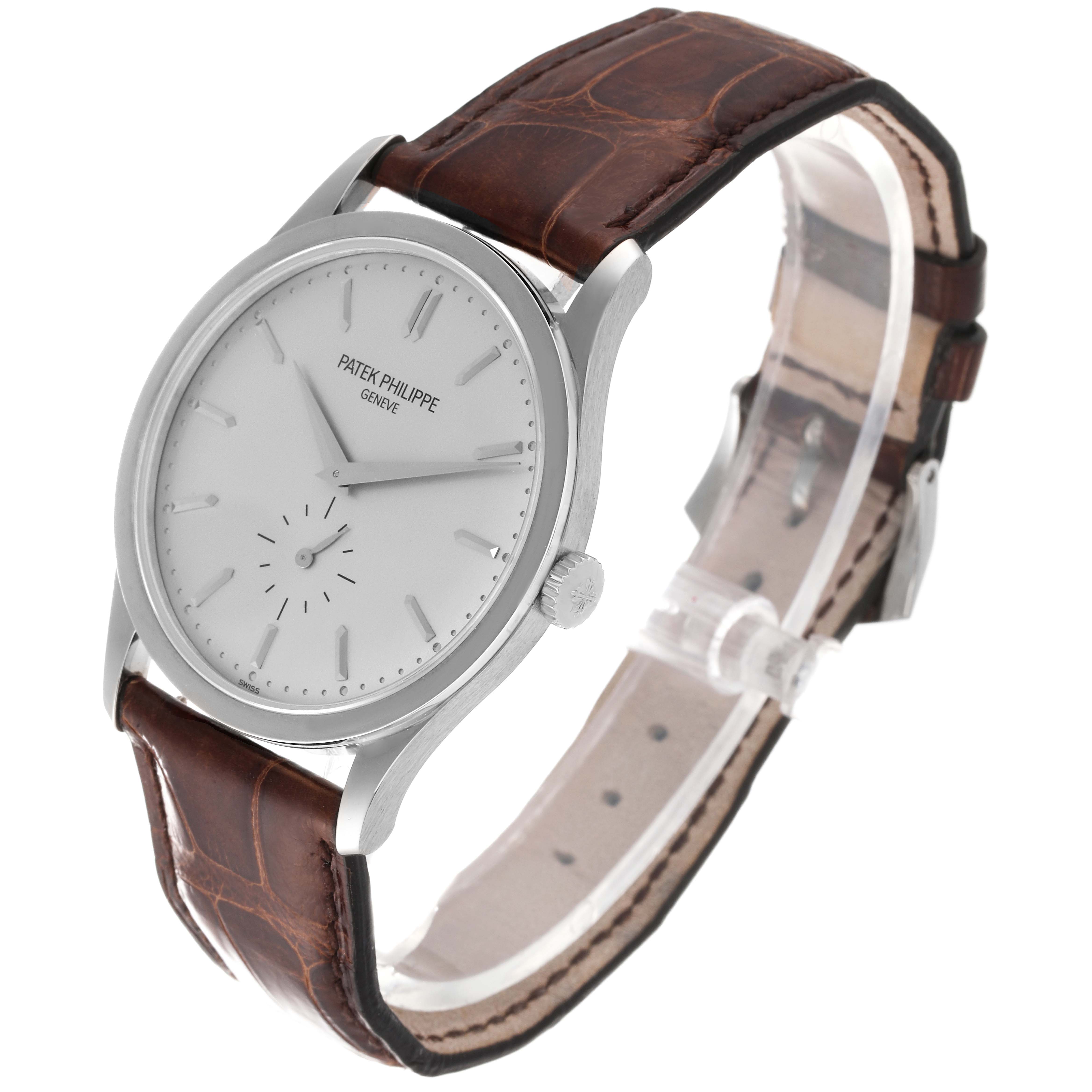 The image shows a front-angle view of a Patek Philippe Calatrava 5196G Men
s White Gold Silver Dial 5196G Men
s White Gold Silver Dial watch with a white dial and brown leather strap.