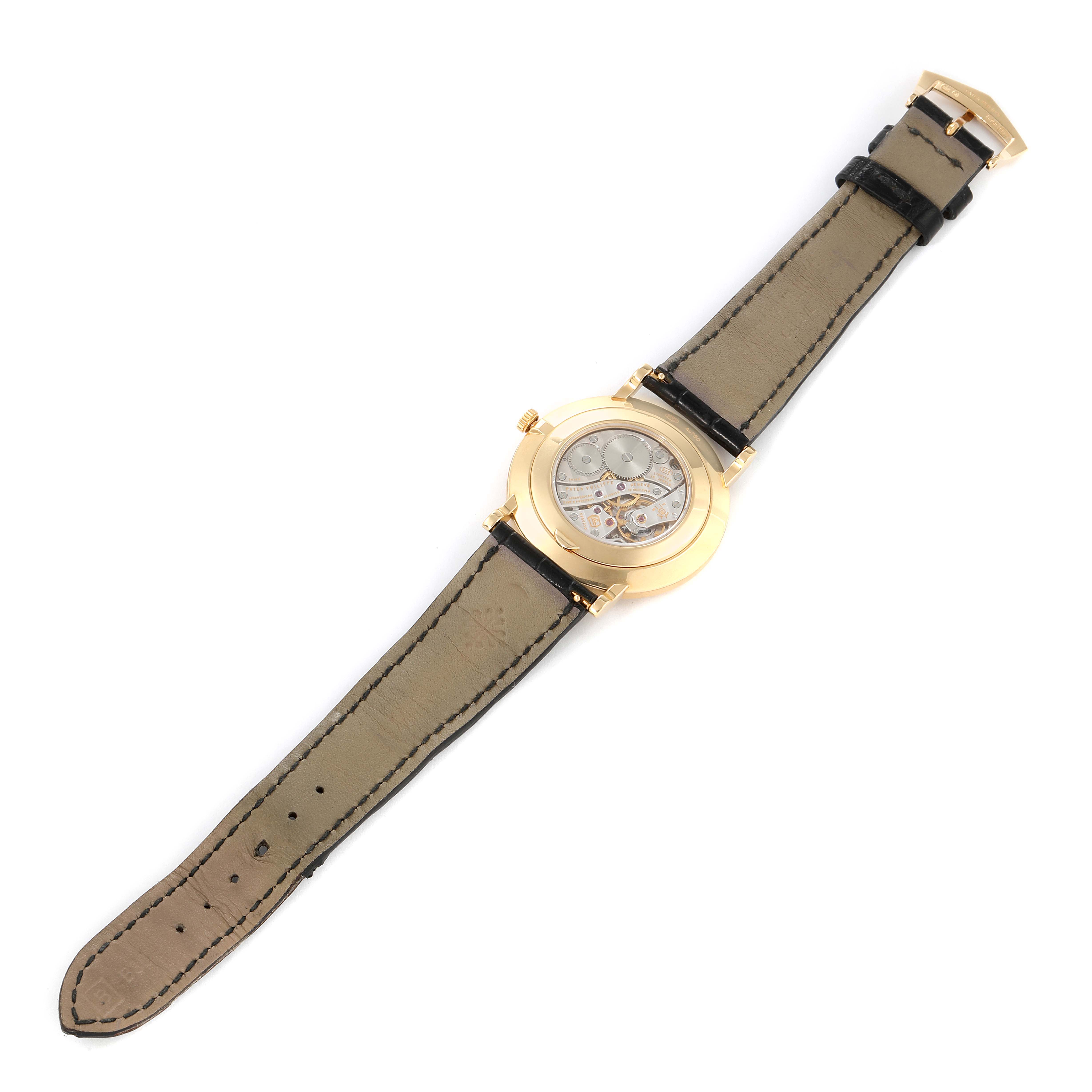 The image shows the back view of a Patek Philippe Calatrava 5119J-001 Men's Yellow Gold White Dial 5119J-001 Men's Yellow Gold White Dial watch, highlighting the transparent case back and leather strap.