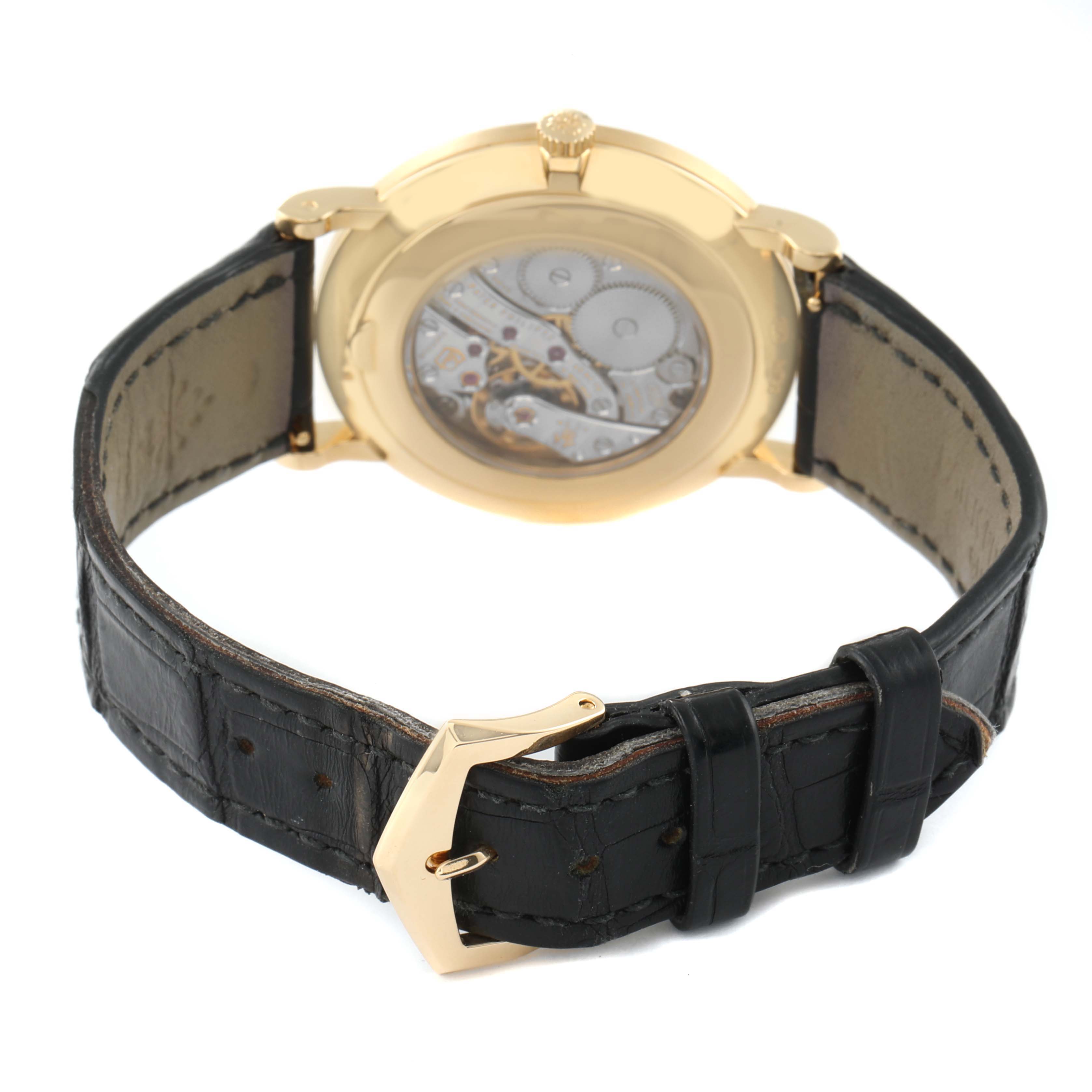 The image shows a rear view of a Patek Philippe Calatrava 5119J-001 Men's Yellow Gold White Dial 5119J-001 Men's Yellow Gold White Dial watch highlighting its open case back and black leather strap.