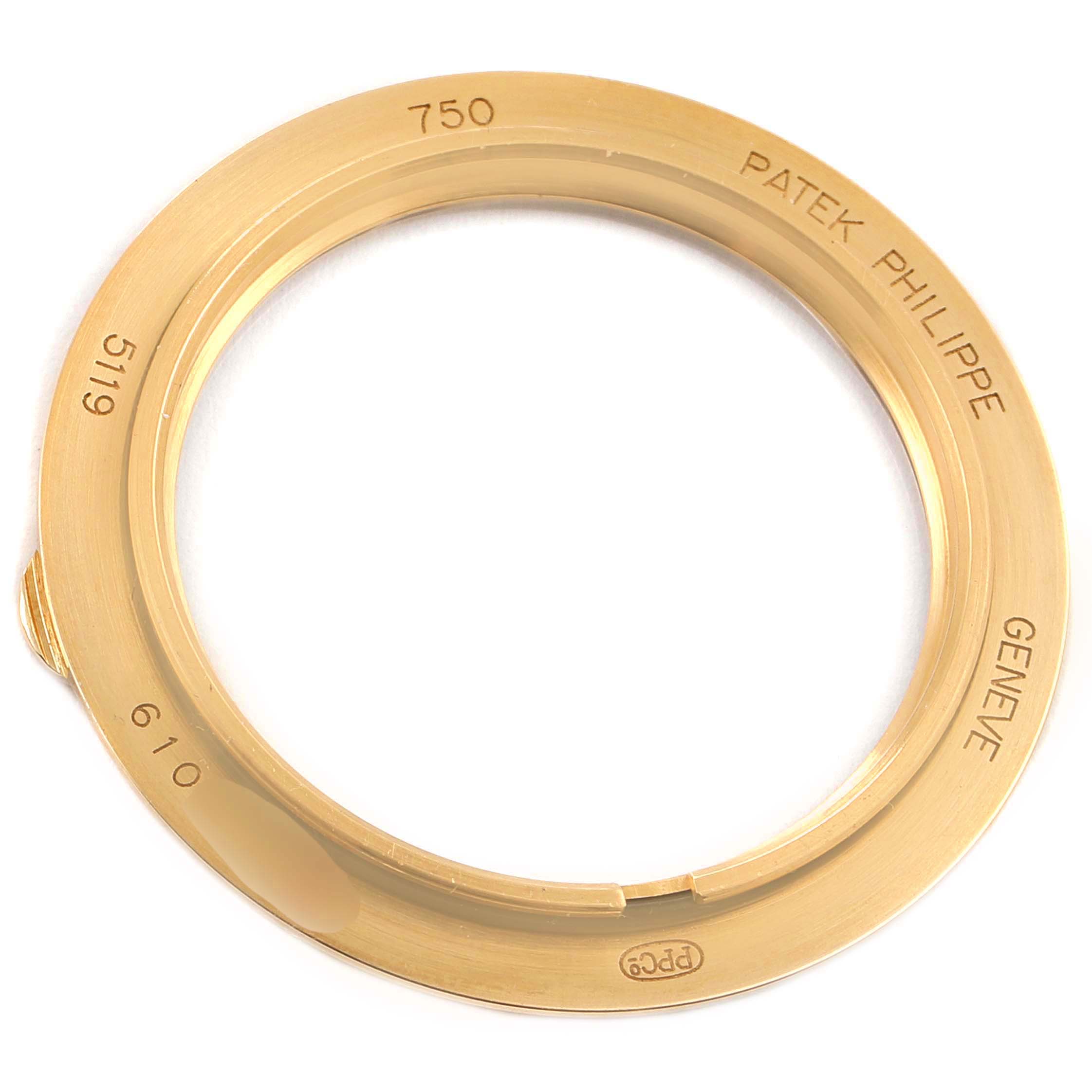 This image shows a gold bezel for the Patek Philippe Calatrava 5119J-001 Men's Yellow Gold White Dial 5119J-001 Men's Yellow Gold White Dial model, viewed from above displaying engravings.