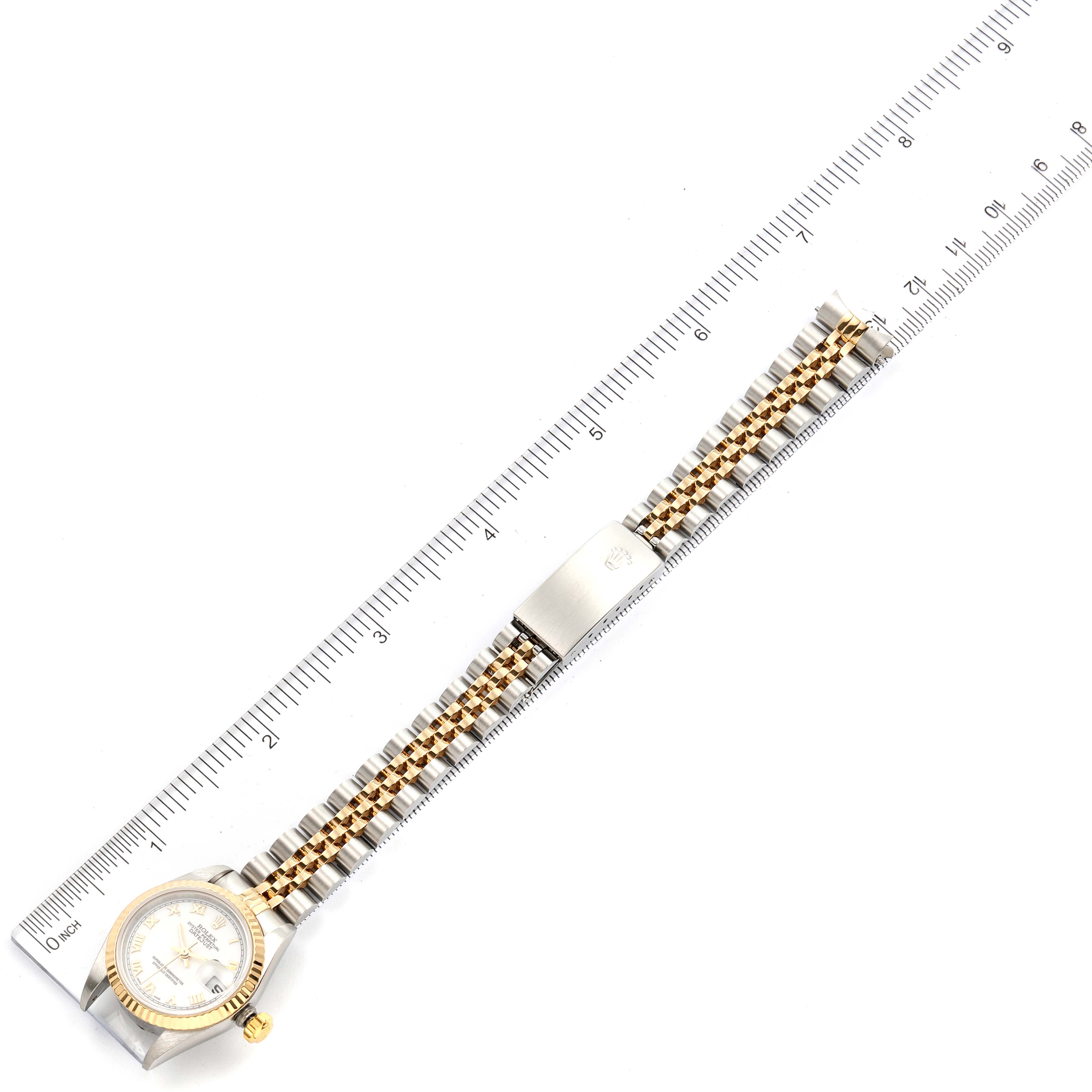 The Rolex Datejust 79173 Women's Steel and Gold (two tone) White Dial 79173 Women's Steel and Gold (two tone) White Dial watch is shown from an overhead view, with the full band extended and a ruler for scale.