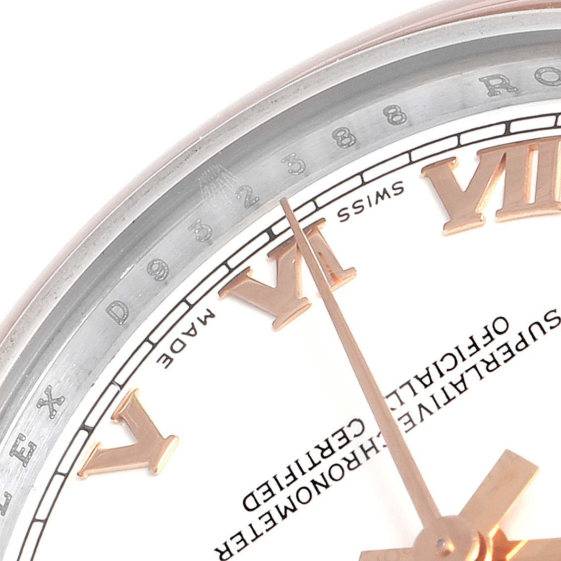 The image shows a close-up of the dial and hour markers of a mid-size Rolex watch, focusing on the Roman numeral VI and surrounding text.