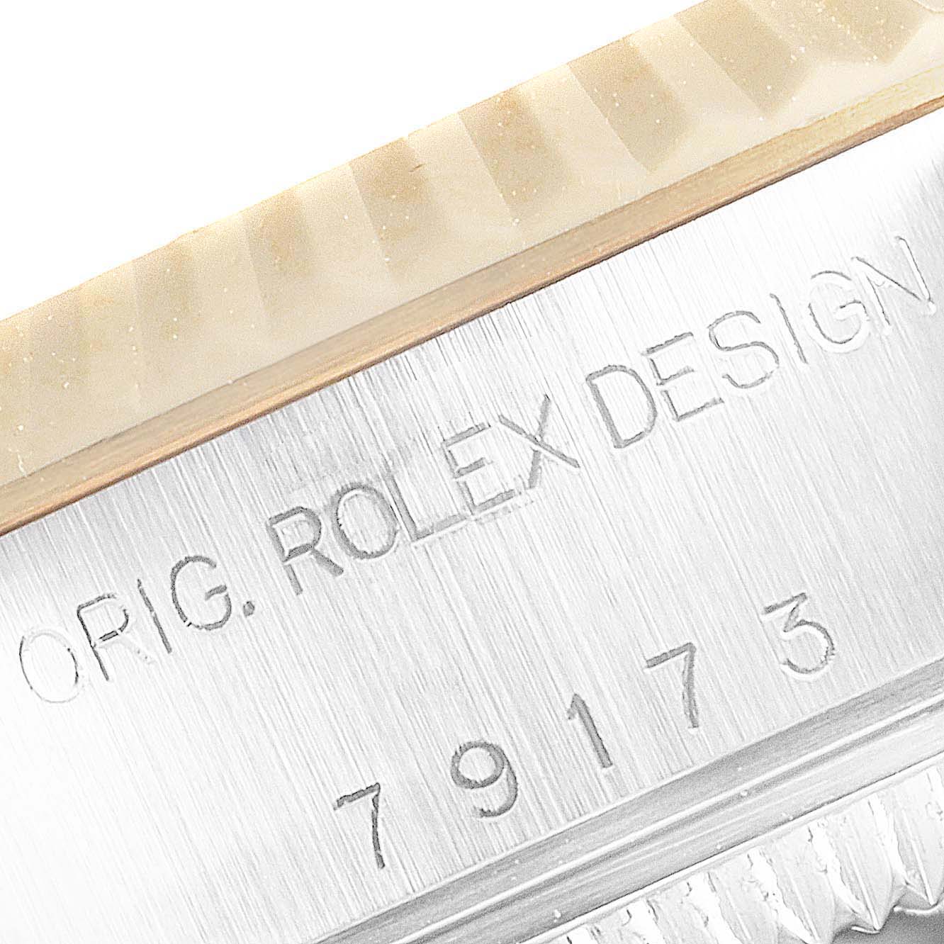 The image shows an angled close-up of the case side of a Rolex Datejust 79173 Women's Steel and Gold (two tone) Blue Dial 79173 Women's Steel and Gold (two tone) Blue Dial watch, displaying the serial number and "ORIG. ROLEX DESIGN" engraving.