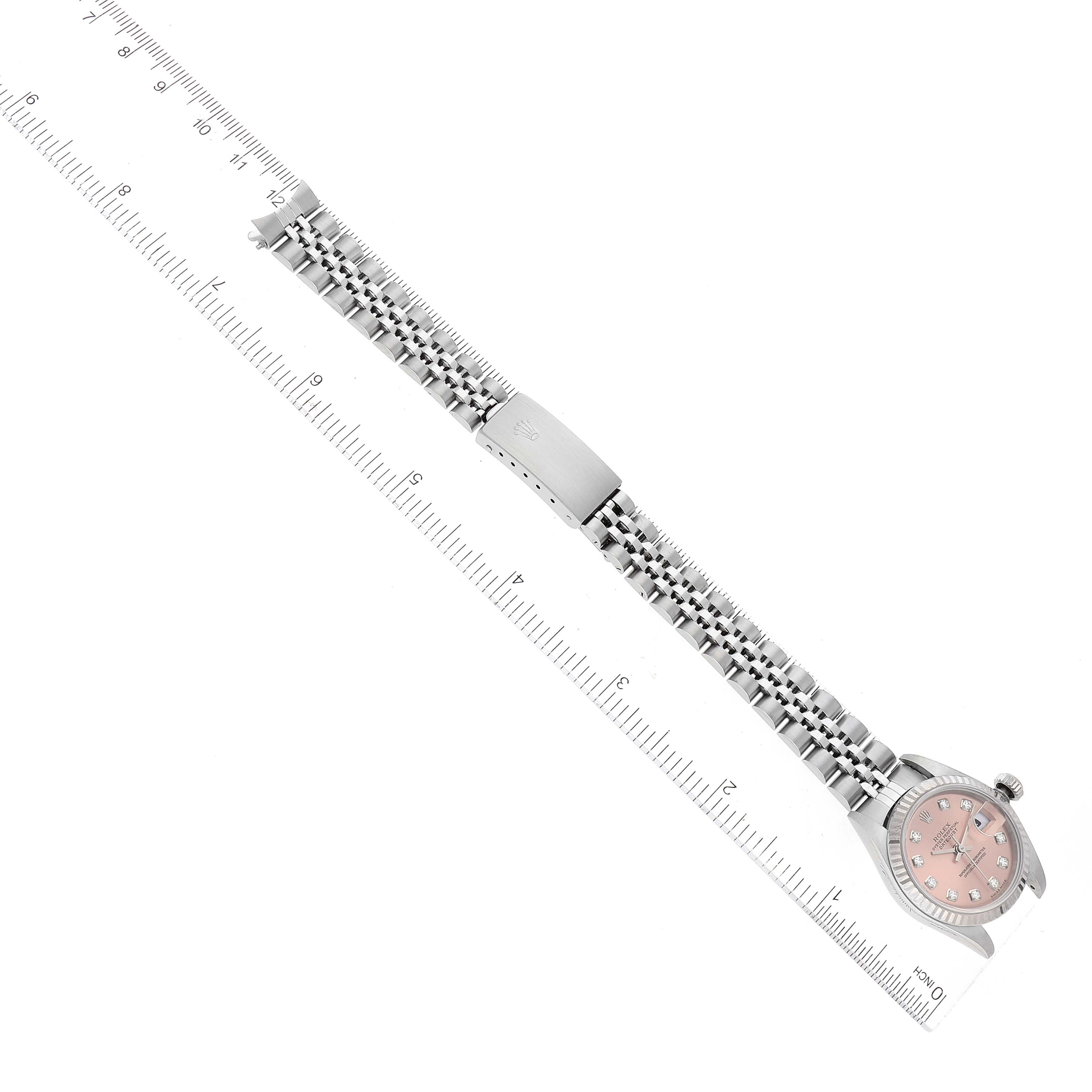 The image shows a Rolex Datejust 79174 Women's Stainless Steel Pink Dial 79174 Women's Stainless Steel Pink Dial watch, focused on the entire watch and bracelet laid flat beside a ruler for scale.