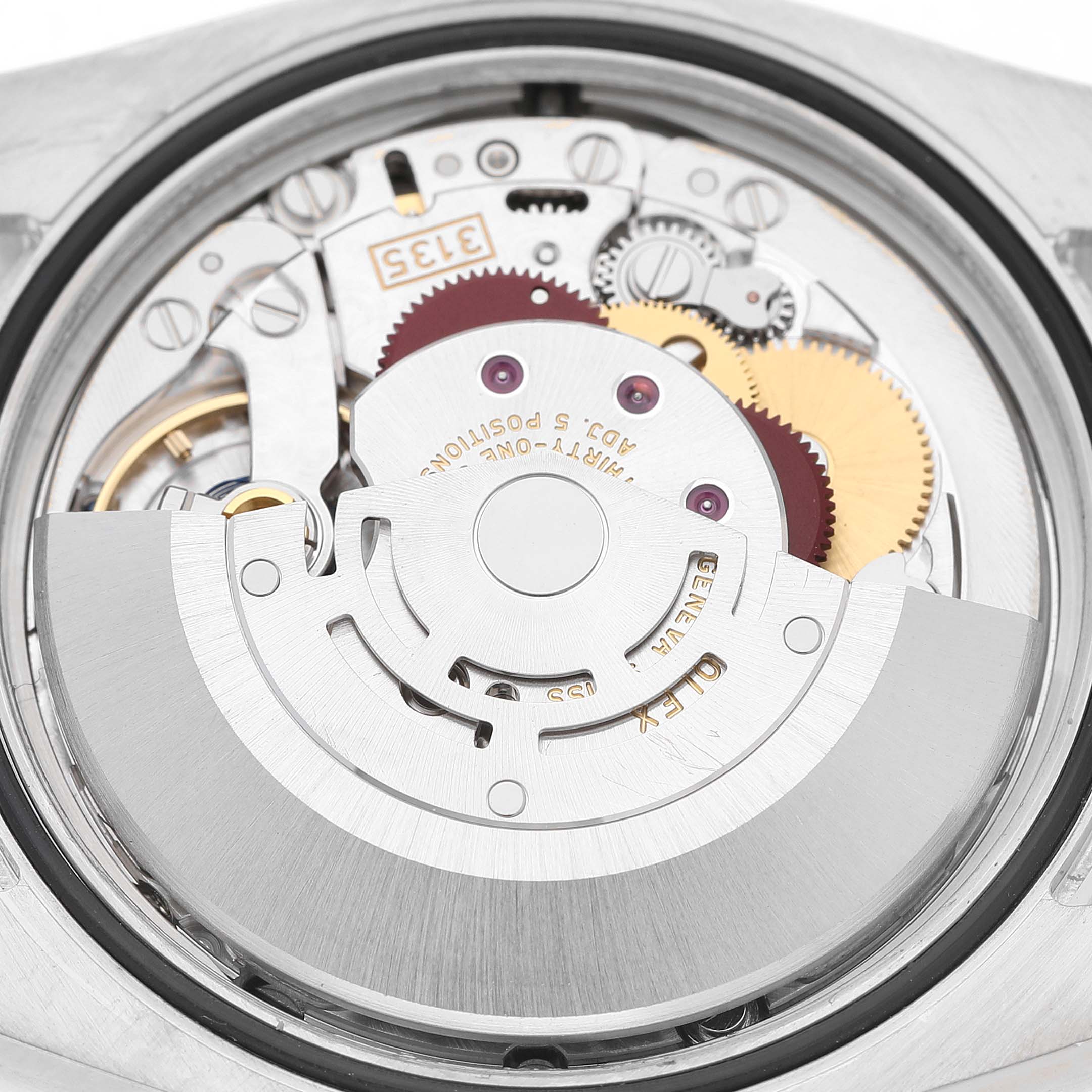 The image shows the movement mechanism of a Rolex Datejust 116243 Men's Steel and Gold (two tone) Black Dial watch at a close-up angle, highlighting gears and components.
