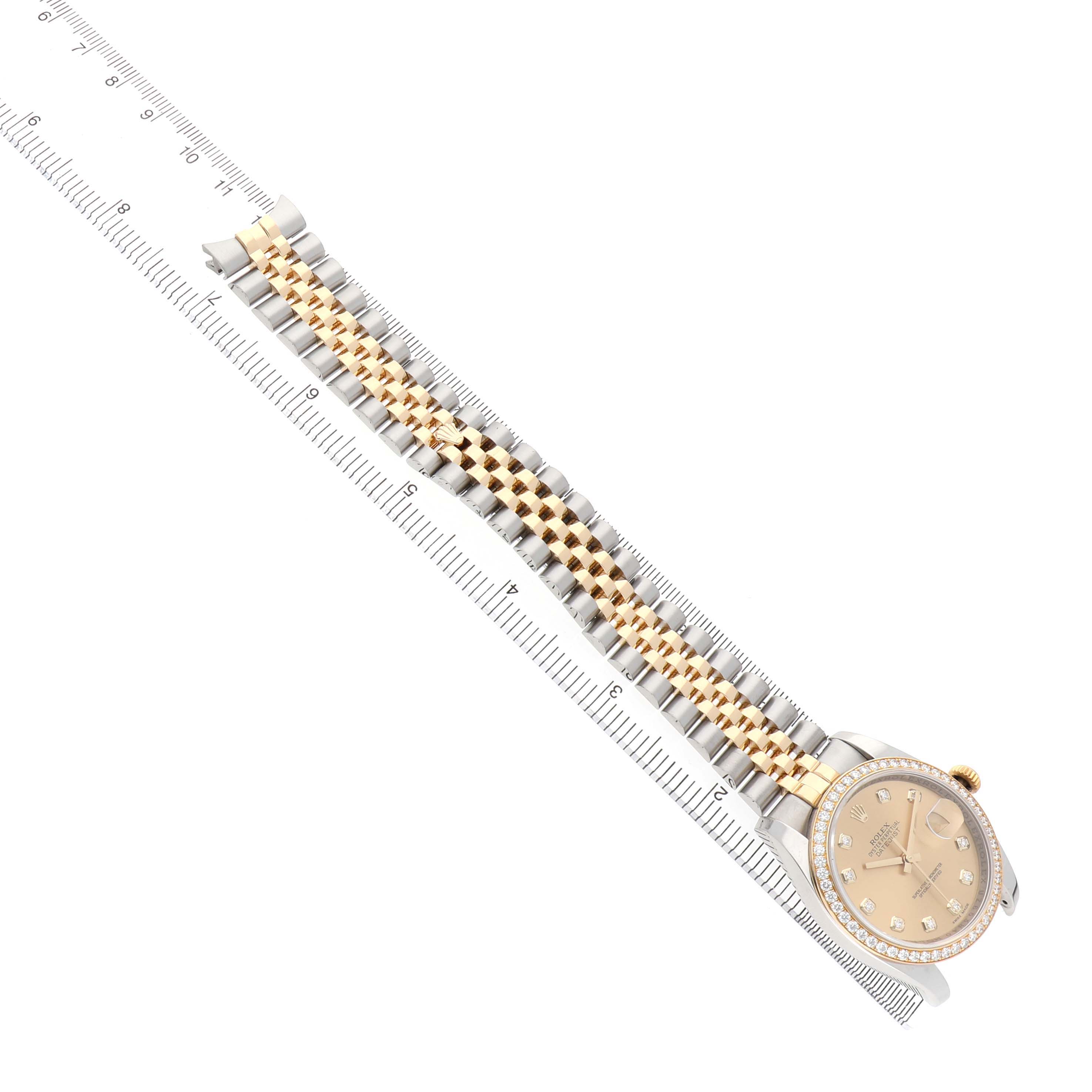 The image shows the Rolex Datejust 116243 Men's Steel and Gold (two tone) Champagne Dial watch at an angled top view, displaying the bracelet and dial with a ruler for scale.