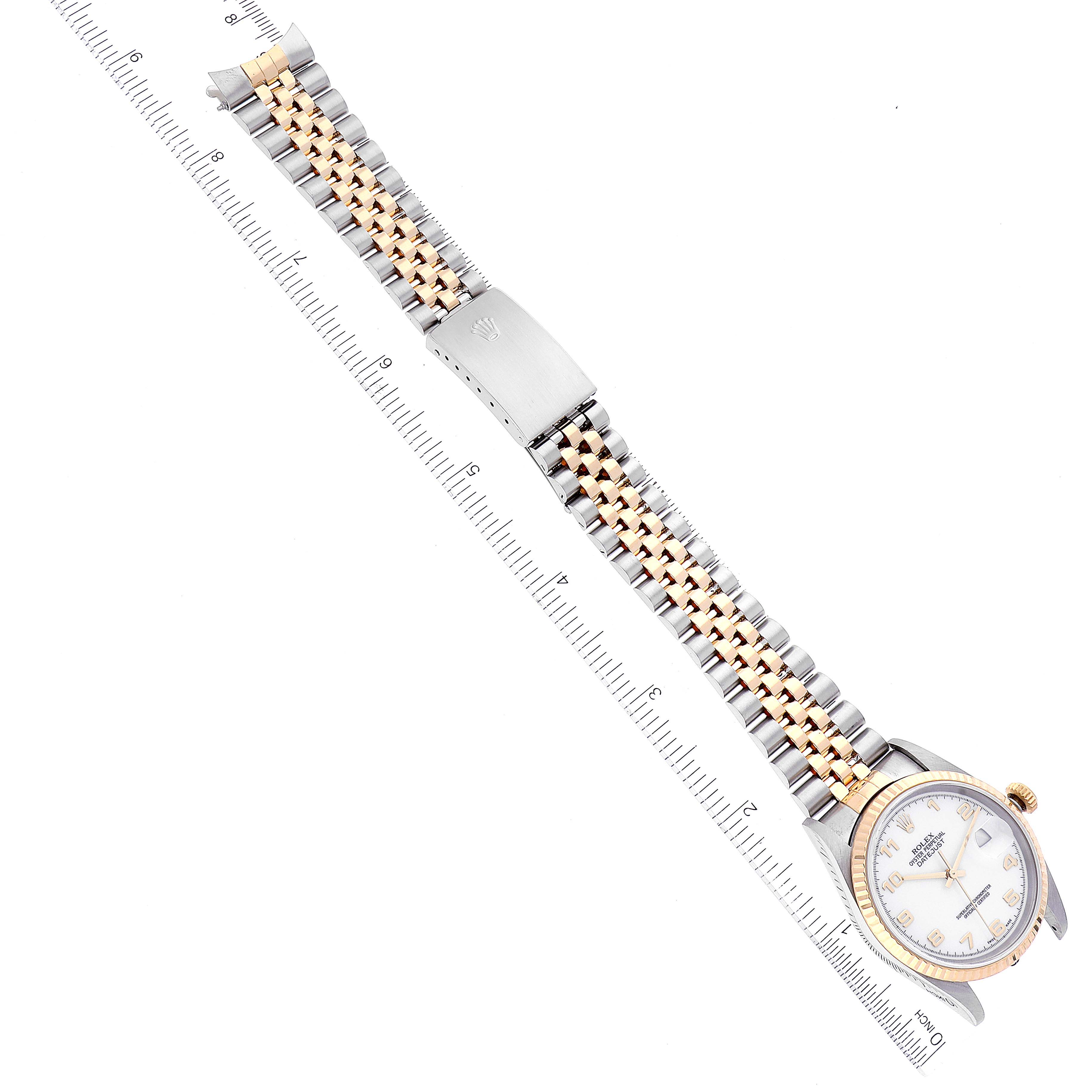 The Rolex Datejust 16233 Men's Steel and Gold (two tone) White Dial 16233 Men's Steel and Gold (two tone) White Dial watch is shown from a top-down angle, displaying the dial, case, and two-tone bracelet adjacent to a ruler.