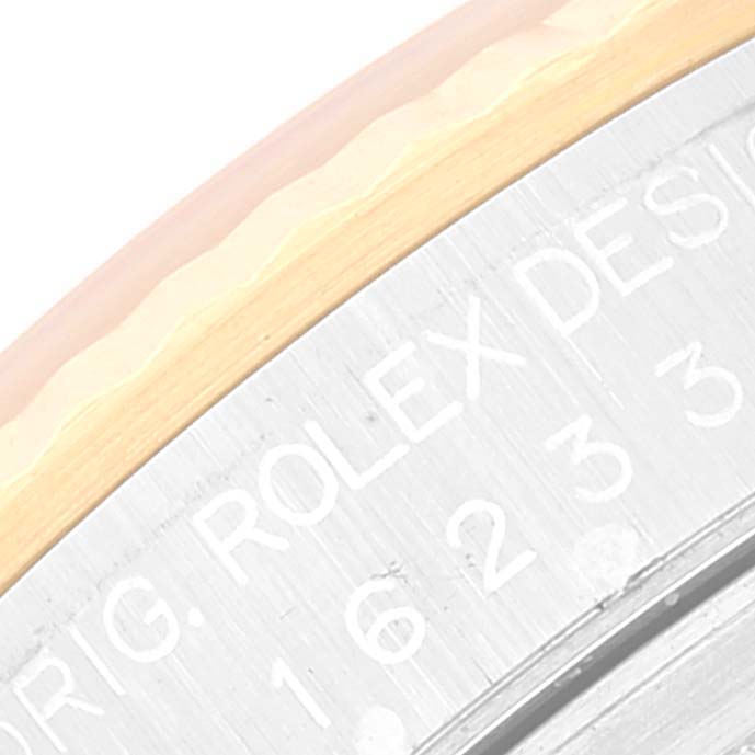 The image shows a close-up angled view of the edge and engraved back of a Rolex Datejust 16233 Men's Steel and Gold (two tone) White Dial 16233 Men's Steel and Gold (two tone) White Dial watch.