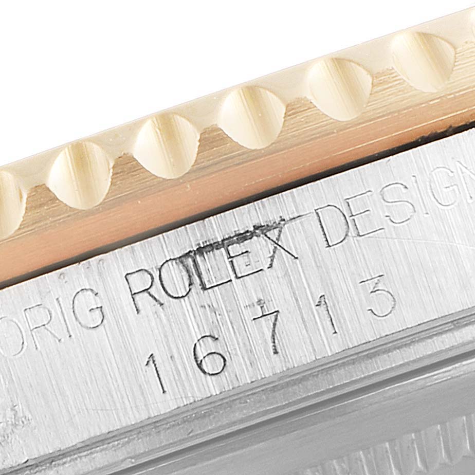 This close-up image of a Rolex GMT-Master 16713 Men's Steel and Gold (two tone) Black Dial 16713 Men's Steel and Gold (two tone) Black Dial shows the model number 16713 engraved on the side of its bezel.