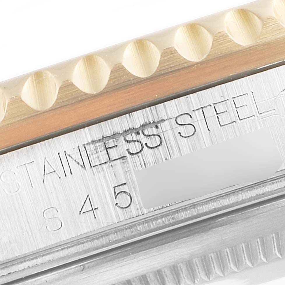 This close-up angle shows the "STAINLESS STEEL" engraving and the border of the bezel of the Rolex GMT-Master 16713 Men's Steel and Gold (two tone) Black Dial 16713 Men's Steel and Gold (two tone) Black Dial.