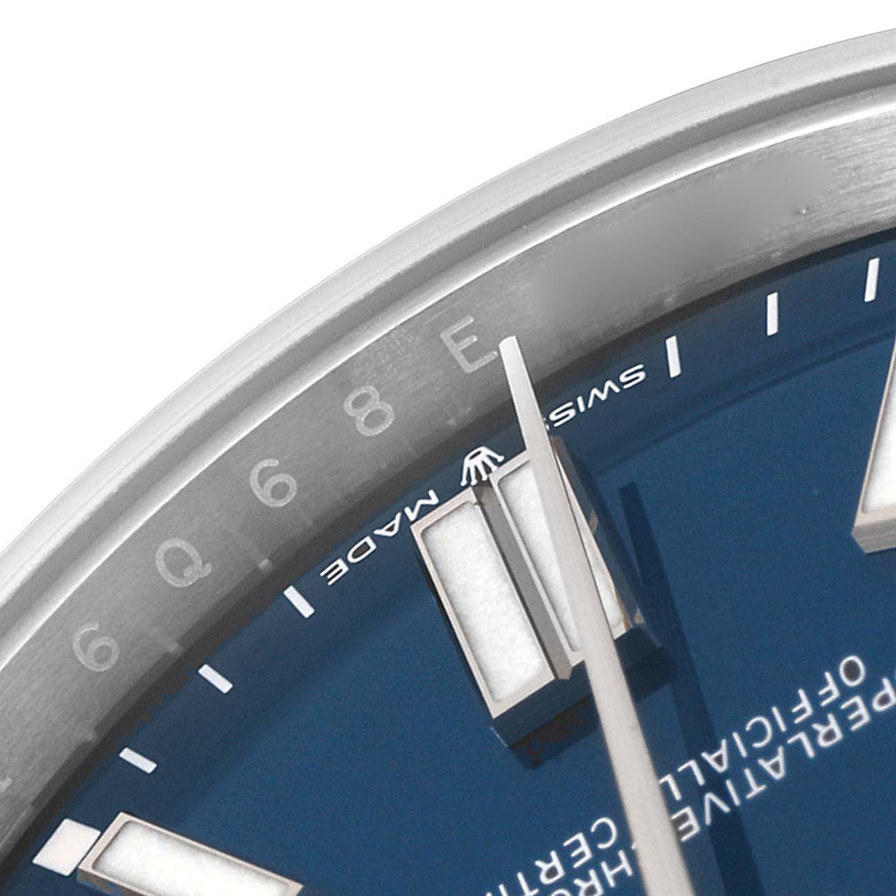 This close-up image of the Rolex Oyster Perpetual 124300 Men
s Stainless Steel Blue Dial 124300 Men
s Stainless Steel Blue Dial watch shows parts of the blue dial, indices, and minute hand, partially displaying the "SWISS MADE" text.