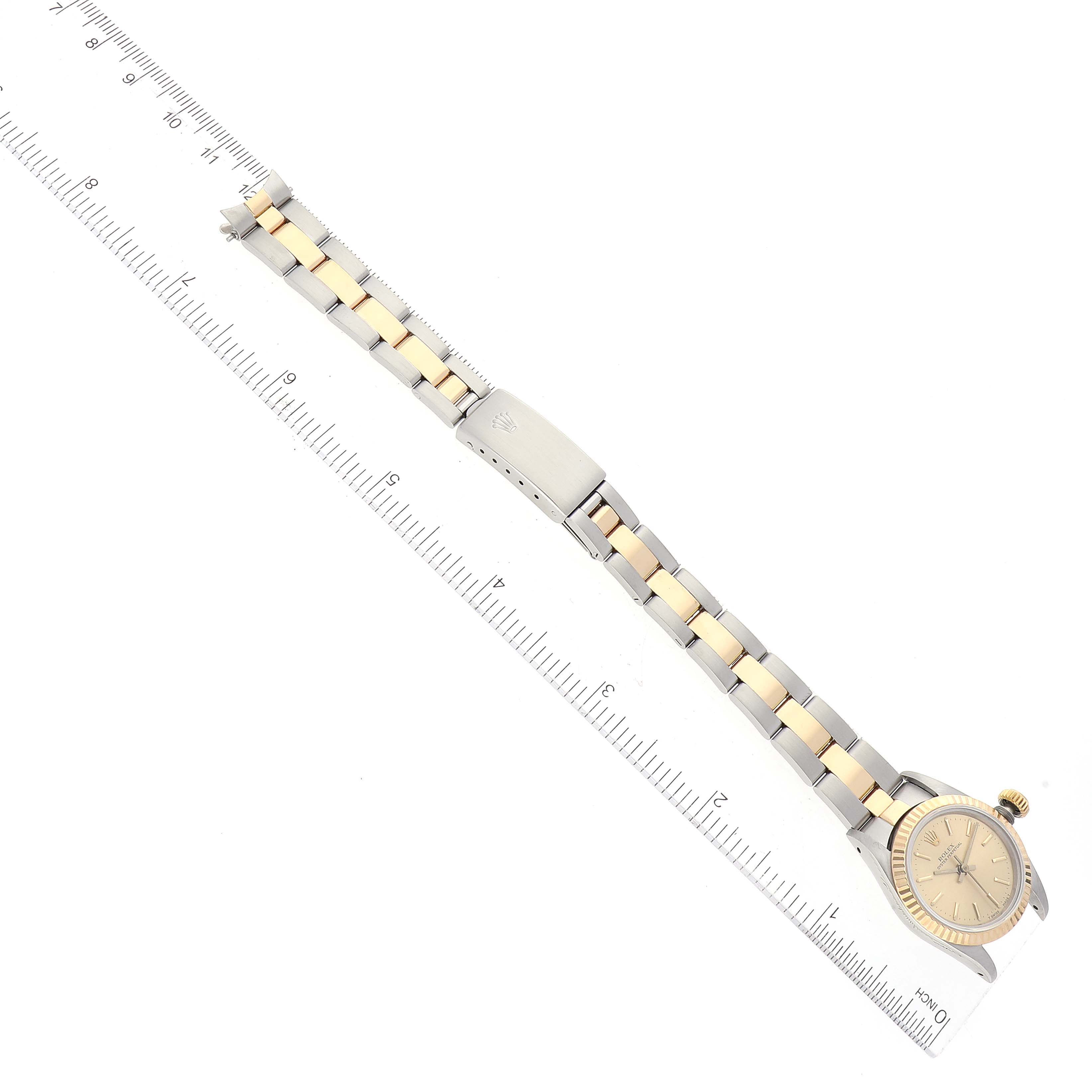 The image shows a Rolex Oyster Perpetual 67193 Women's Steel and Gold (two tone) Champagne Dial 67193 Women's Steel and Gold (two tone) Champagne Dial watch flat with ruler measurements for size reference.