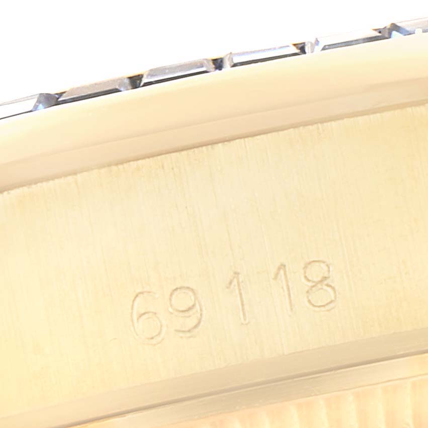 The image shows the side angle of a Rolex President 69118 Women's Yellow Gold Champagne Dial 69118 Women's Yellow Gold Champagne Dial model watch, specifically focusing on the engraved serial number.