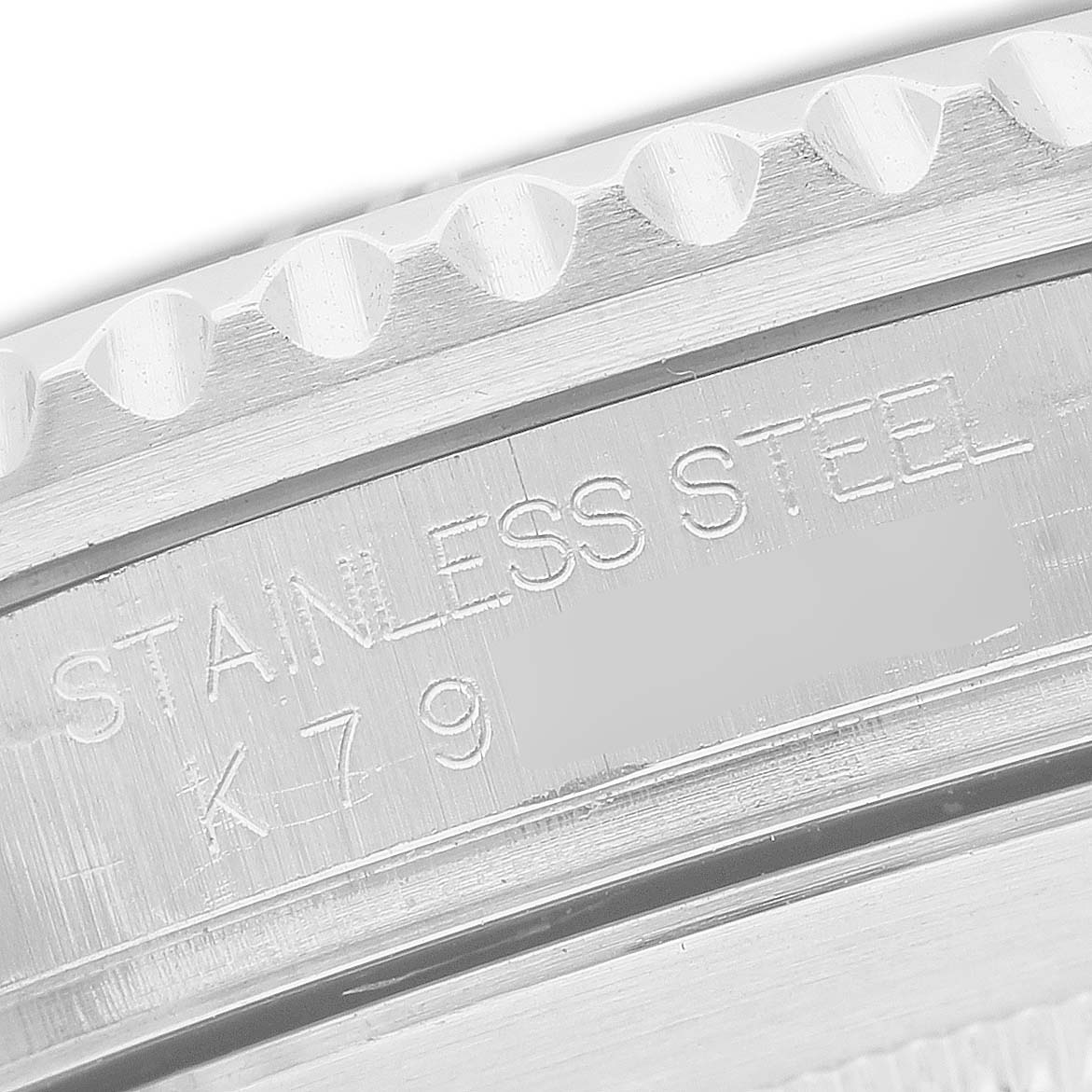 The image shows a close-up of the stainless steel engraving on the bezel and case of a Rolex Submariner 16610 Men's Stainless Steel Black Dial watch.