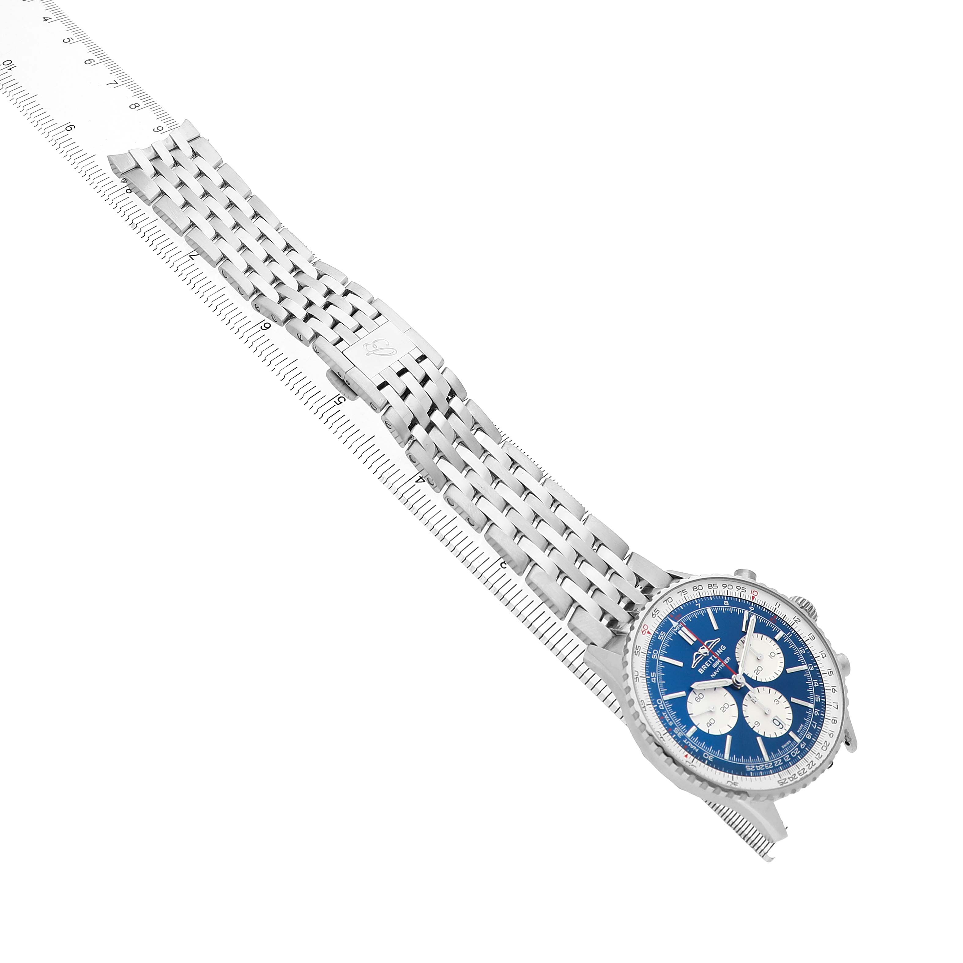 The Breitling Navitimer AB0137 Men's Stainless Steel Blue Dial is shown from a top angle, displaying the dial and full metal bracelet alongside a measuring tool.