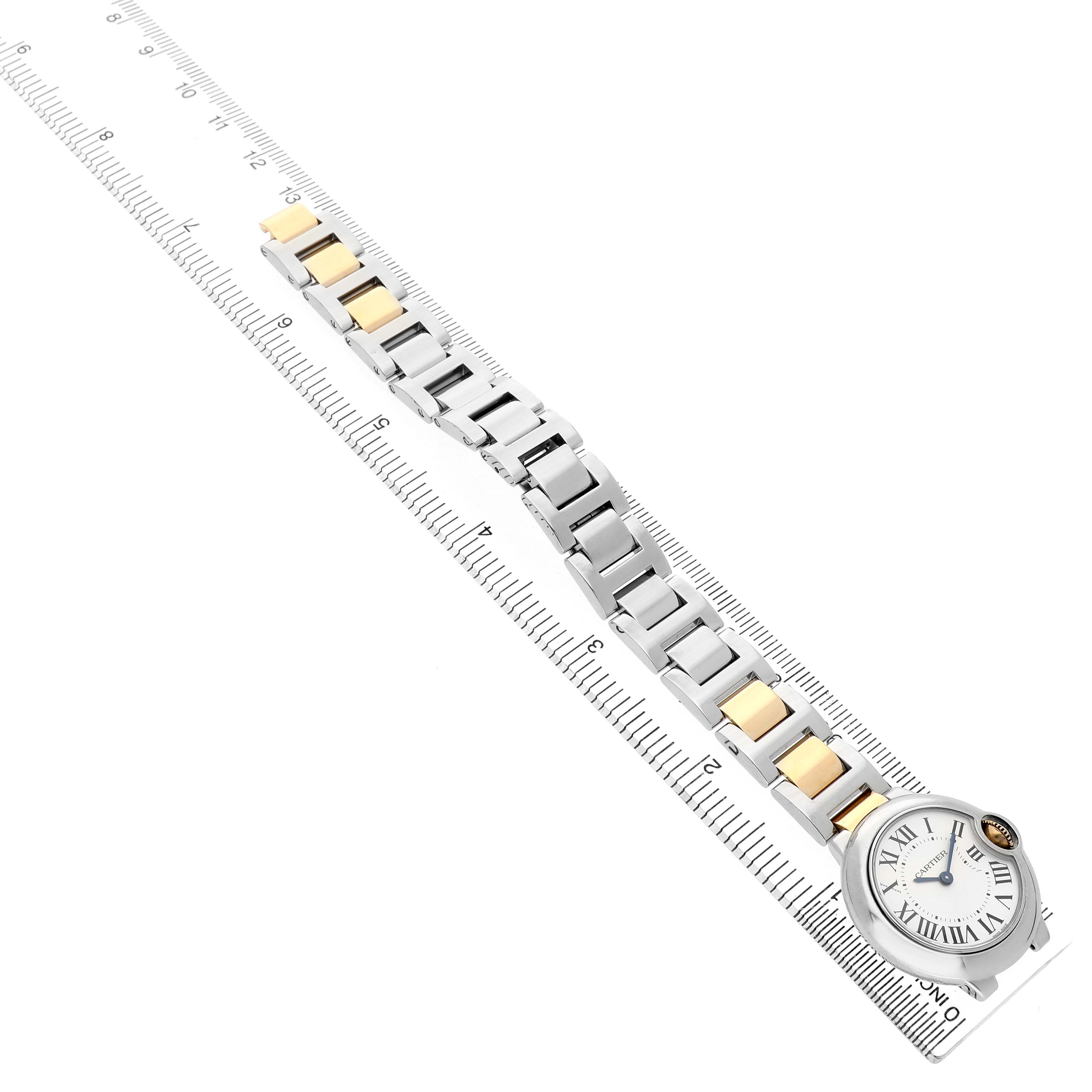 The Cartier Ballon Bleu W69007Z3 Women's Steel and Gold (two tone) Silver Dial watch is shown from a top-down angle, highlighting its bracelet and face aligned with a ruler.