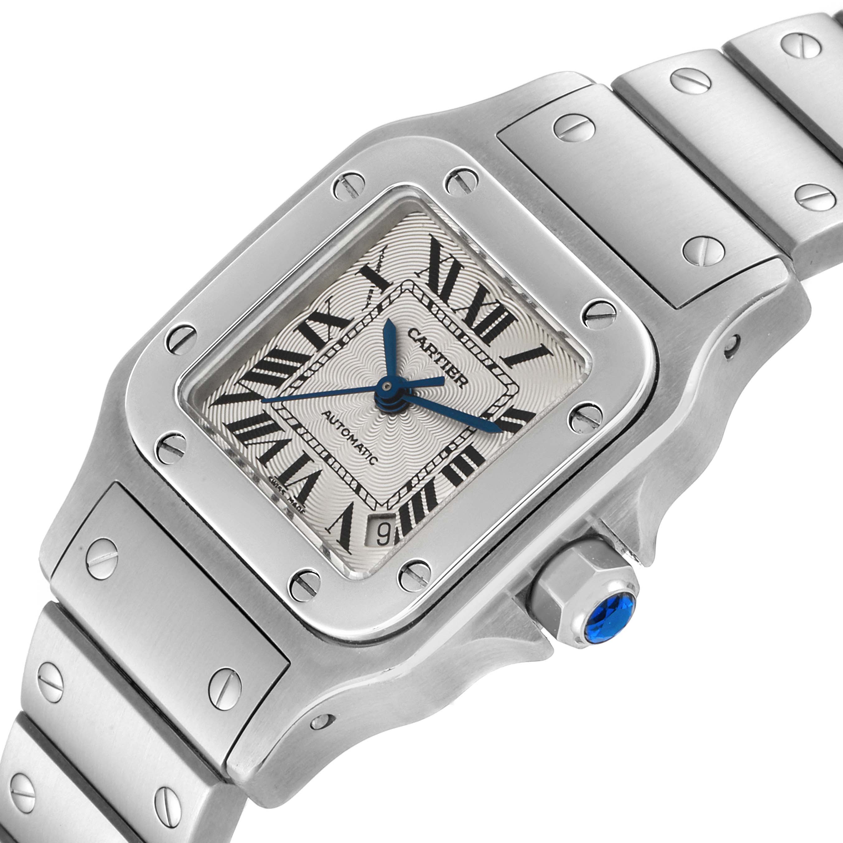 The image shows a close-up of the Santos de Cartier watch face, bezel, and partially the bracelet, viewed at an angle.
