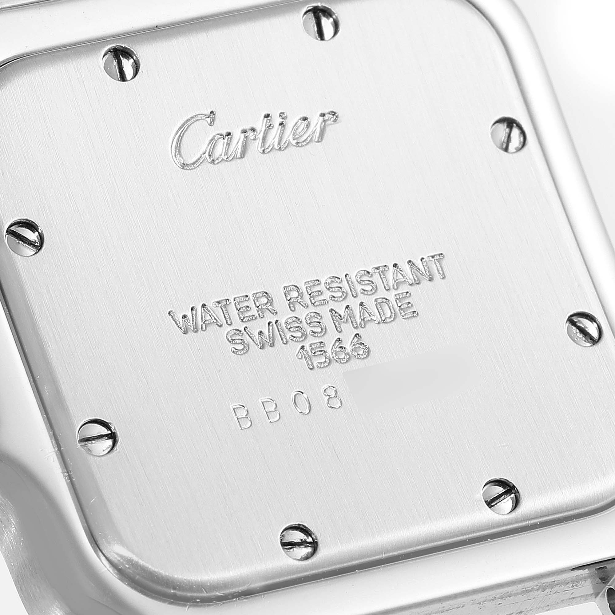 The image shows the back case of a Santos model watch by Cartier, highlighting engraving details and screws.
