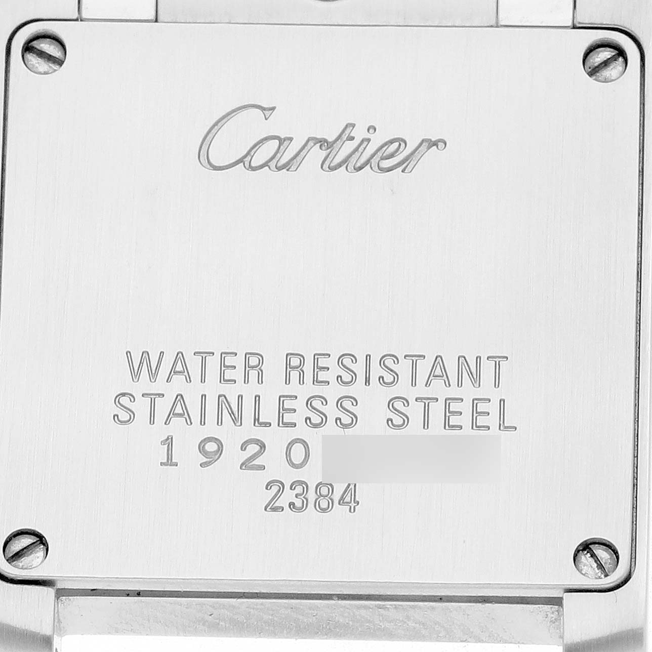 The image shows the back case of a Cartier Tank Francaise W51008Q3 Women's Stainless Steel Silver Dial watch, featuring engravings and screws.