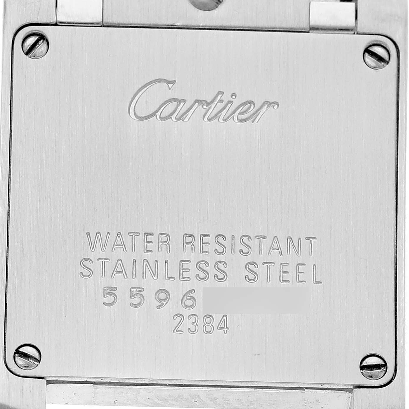 The image shows the backside of a Cartier Tank Française watch, highlighting its stainless steel case and engraved details.
