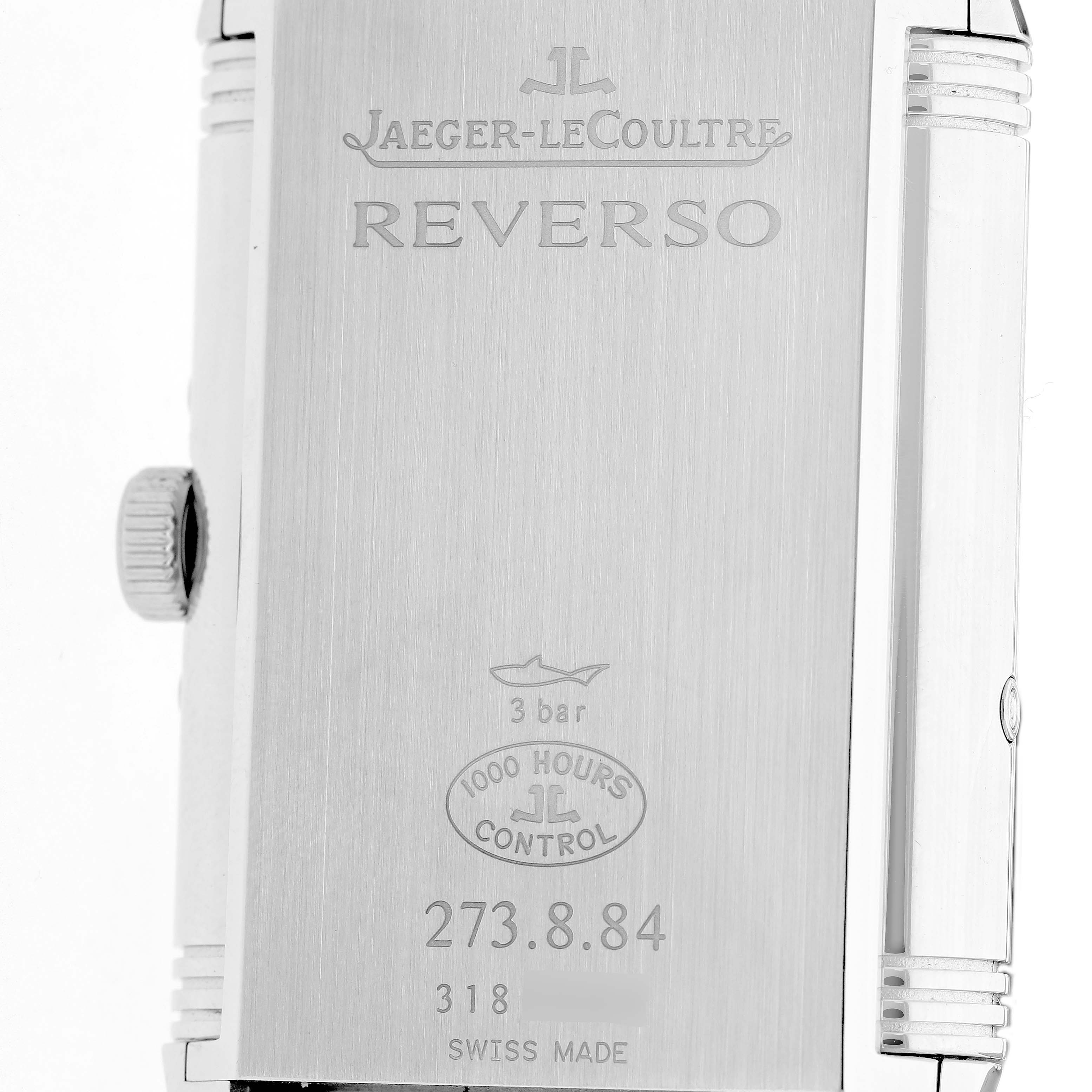 The image shows the back case of the Jaeger-LeCoultre Reverso watch, highlighting the engravings and crown on the side.