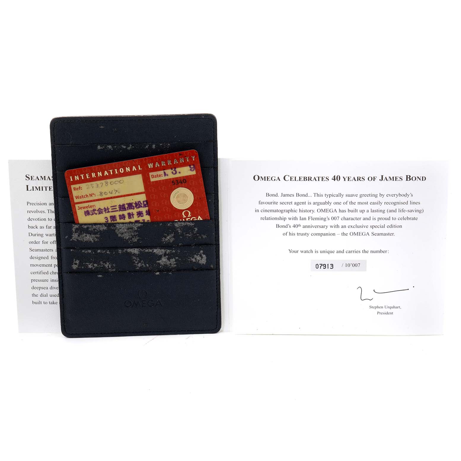 The image shows the warranty card and documentation for an Omega Seamaster 2537.80.00 Men's Stainless Steel Blue Dial 2537.80.00 Men's Stainless Steel Blue Dial watch, celebrating 40 years of James Bond, displayed from a top-down angle.