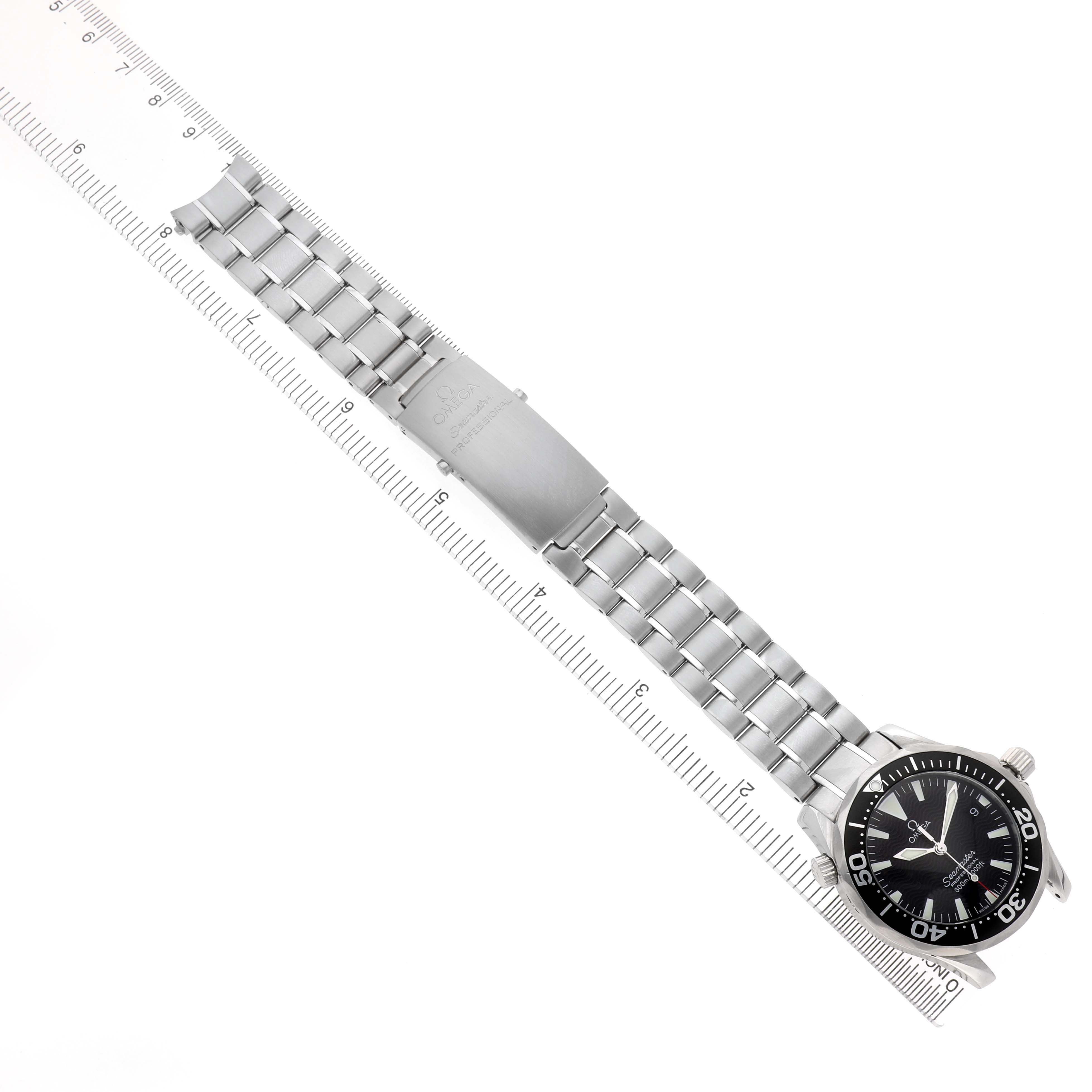 The Omega Seamaster 2262.50.00 Men's Stainless Steel Black Dial watch is shown from an angled top view displaying the full bracelet and clasp alongside a ruler.