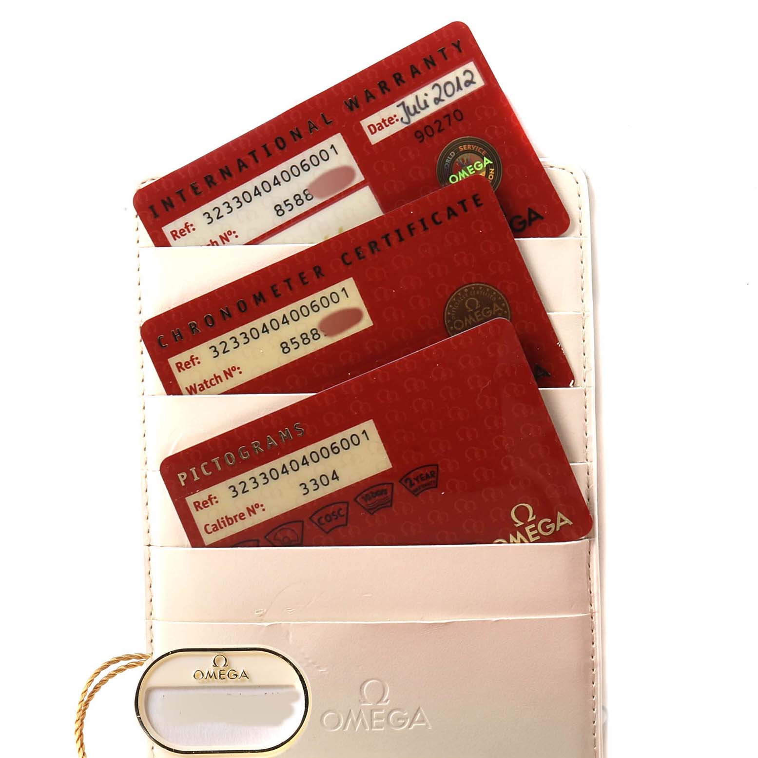 The image shows three red cards for an Omega Speedmaster 323.30.40.40.06.001 Men's Stainless Steel Grey Dial, including a warranty, chronometer certificate, and pictograms, in a white cardholder.