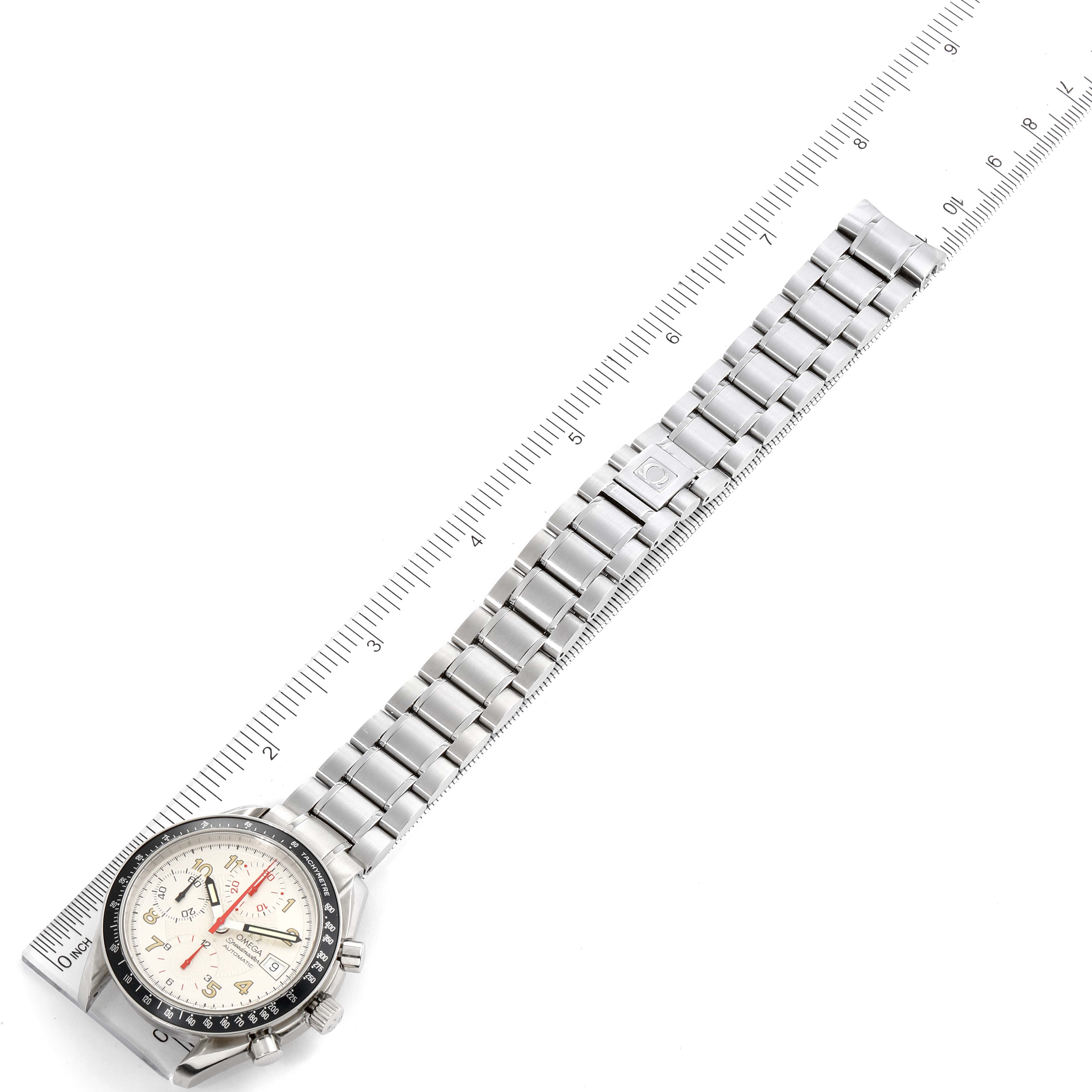 The Omega Speedmaster 3513.33.00 Men
s Stainless Steel White Dial 3513.33.00 Men
s Stainless Steel White Dial watch is shown with its bracelet extended, positioned next to a measuring ruler.