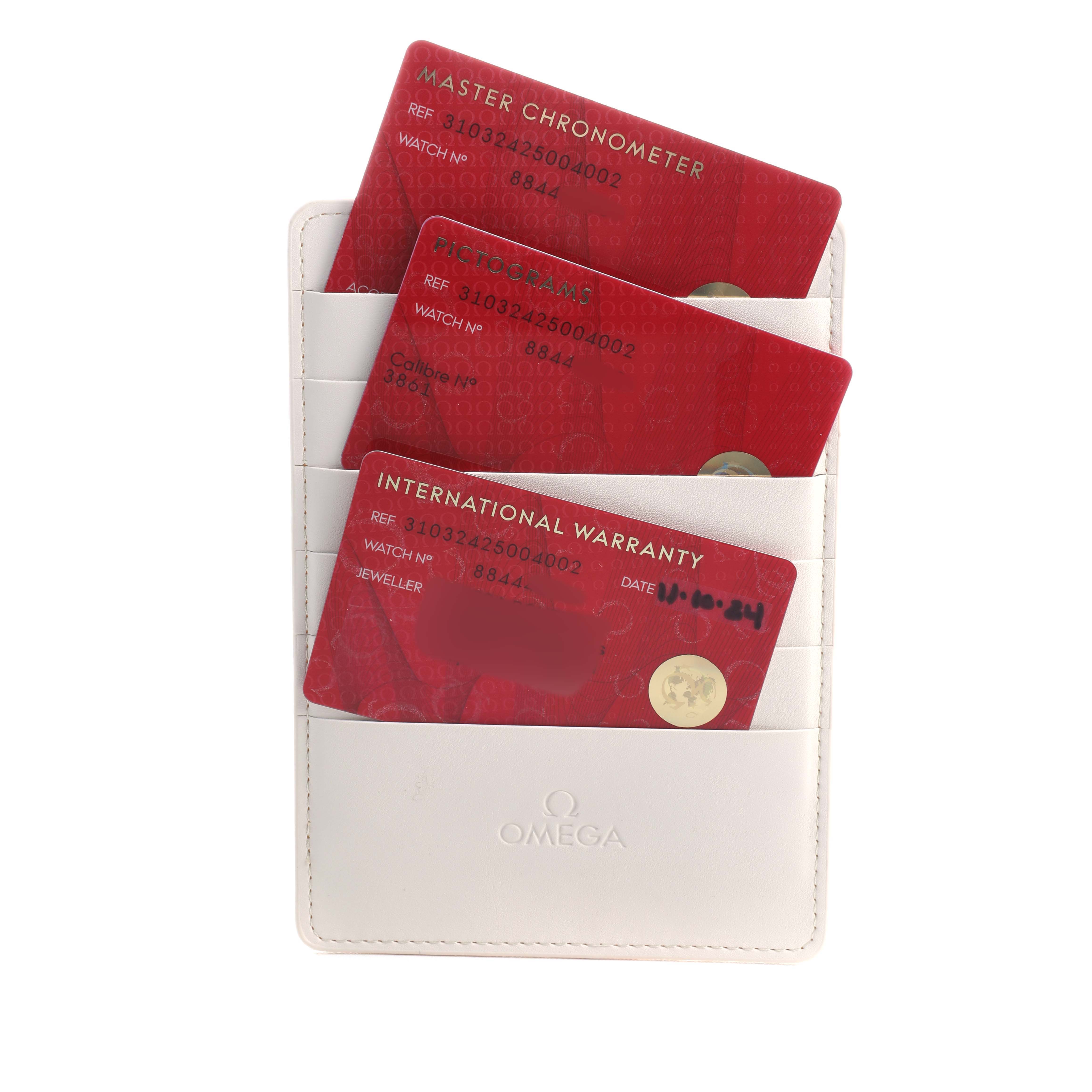 The image shows warranty documents for an Omega Speedmaster 310.32.42.50.04.002 Men's Stainless Steel White Dial, displayed in a white branded cardholder.