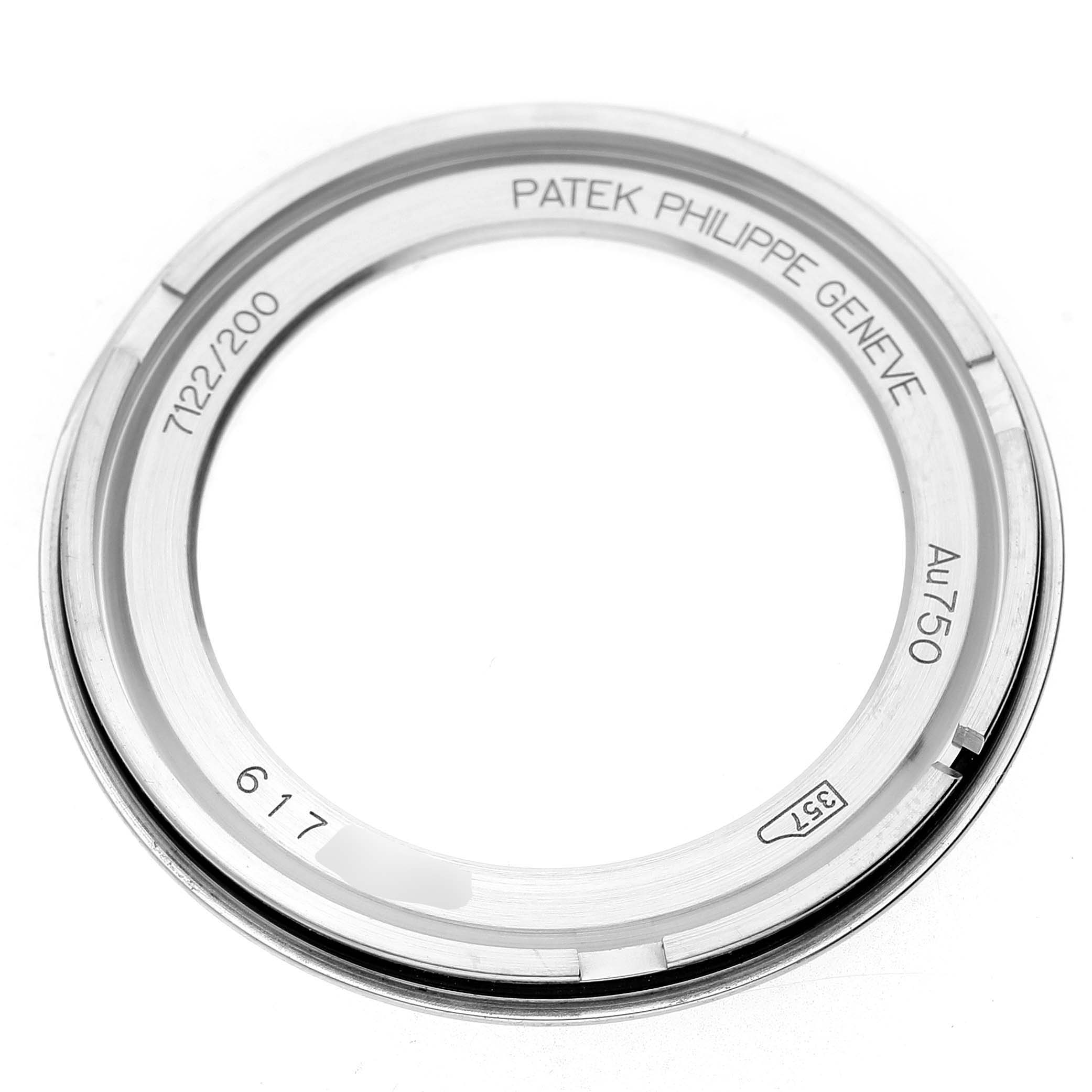The image shows the bezel of a Patek Philippe Calatrava 7122/200G-001 Women's White Gold White Dial watch, viewed from a top-down angle, highlighting engravings and markings.