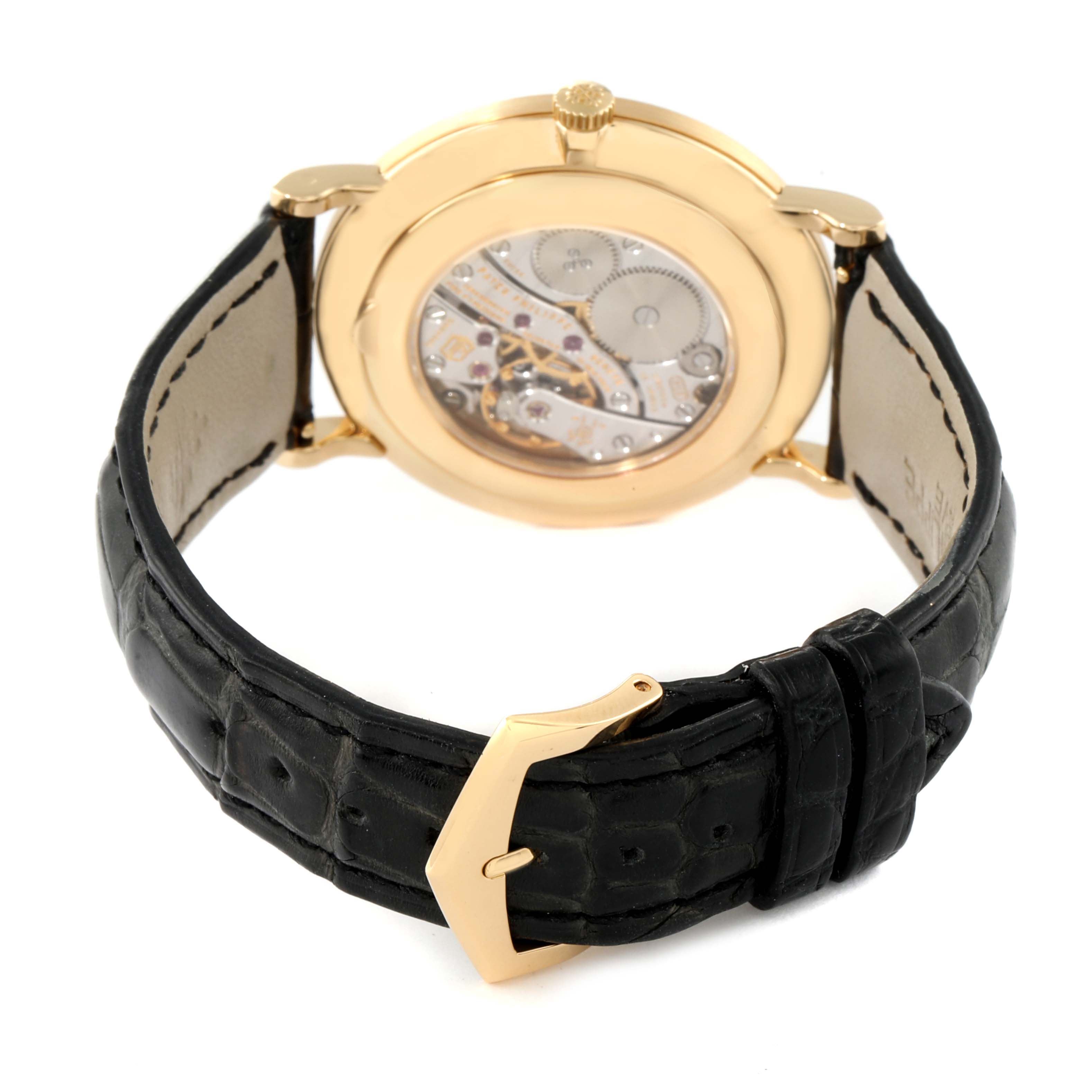 The image shows the back view of a Patek Philippe Calatrava 5119J Men's Yellow Gold White Dial 5119J Men's Yellow Gold White Dial watch, highlighting its transparent case back and black strap with a gold buckle.