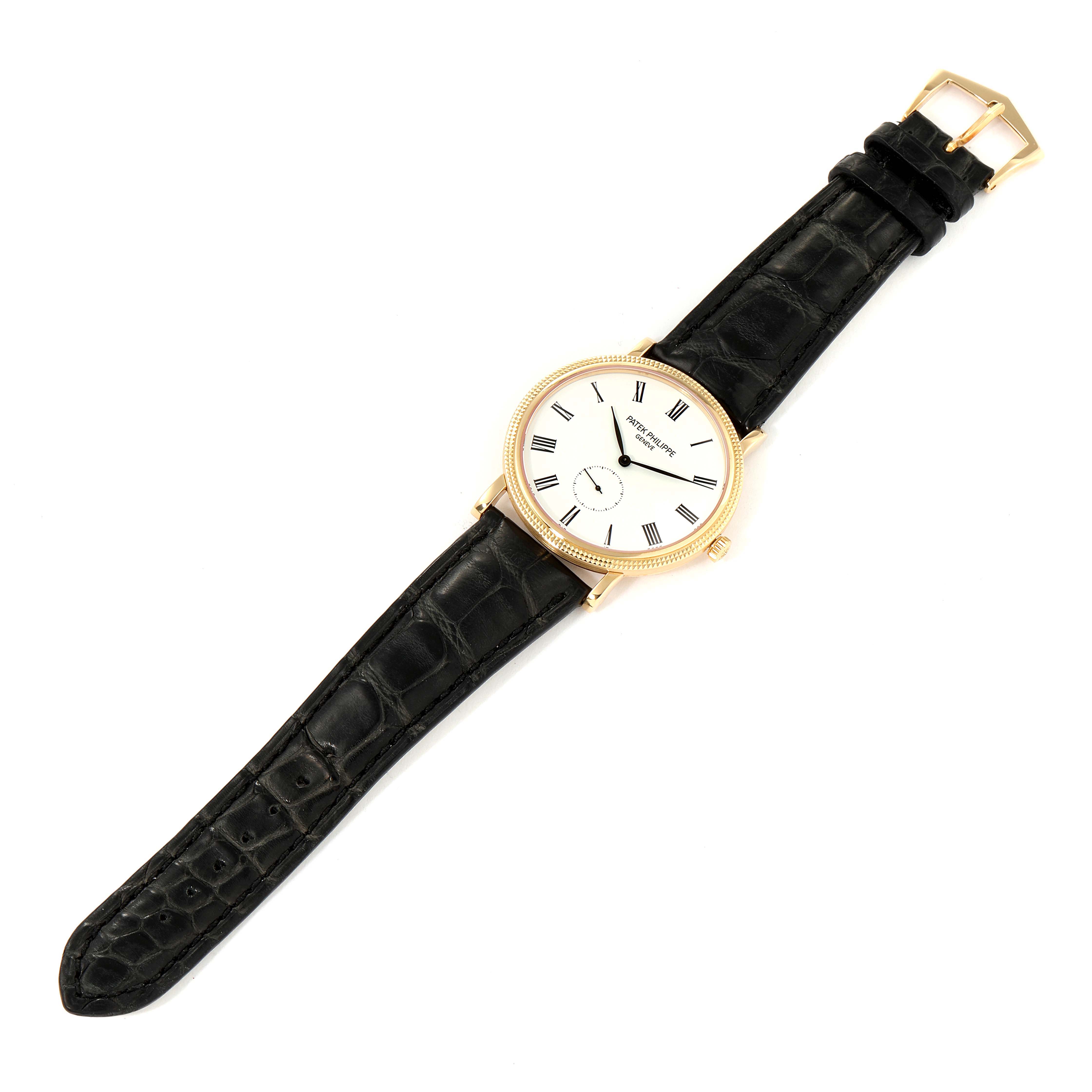 The image shows a top view of a Patek Philippe Calatrava 5119J Men's Yellow Gold White Dial 5119J Men's Yellow Gold White Dial watch with a black leather strap and gold case.