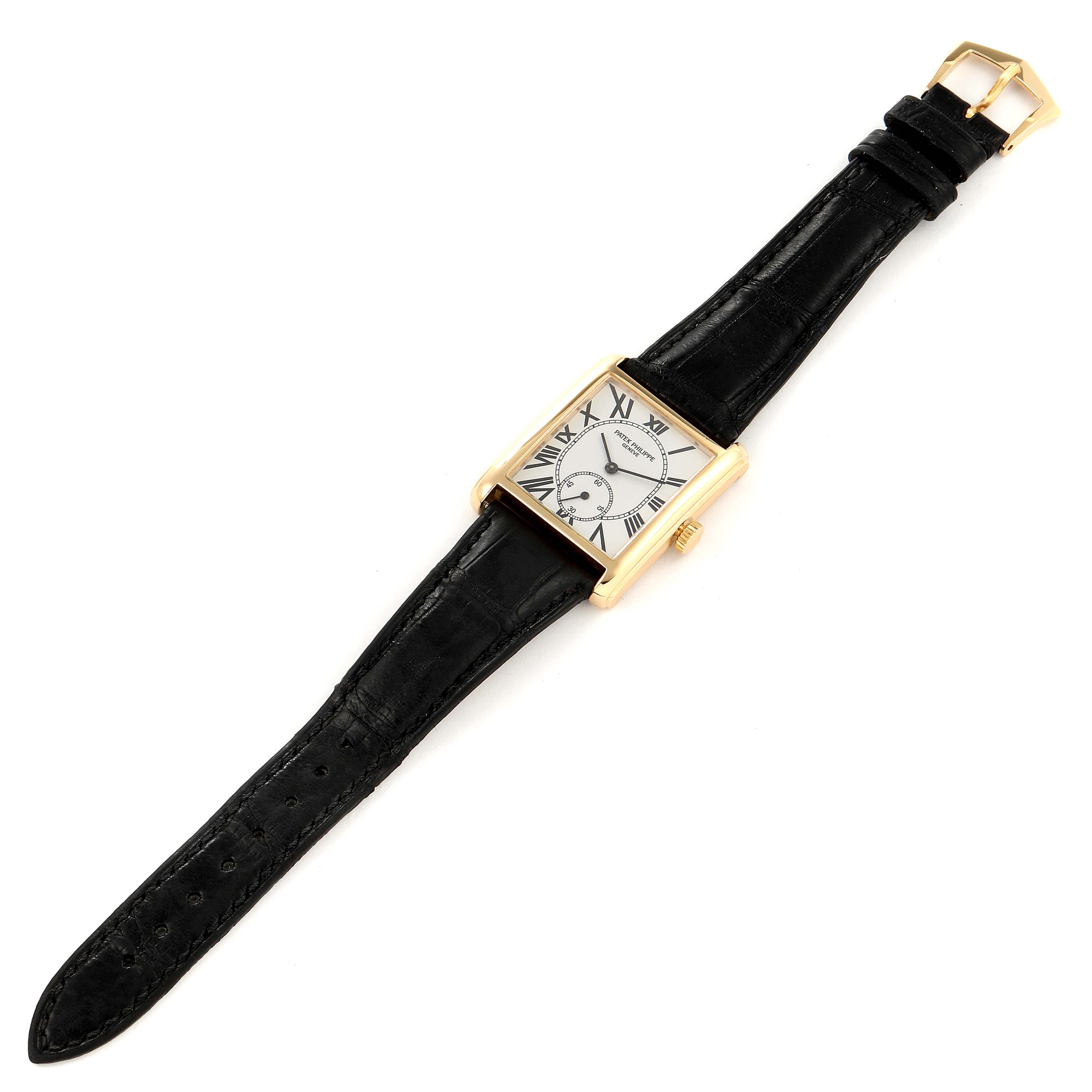 The Patek Philippe Gondolo 5014J Men's Yellow Gold Silver Dial 5014J Men's Yellow Gold Silver Dial watch is shown from a top-down angle, displaying its face, black leather strap, and gold buckle.