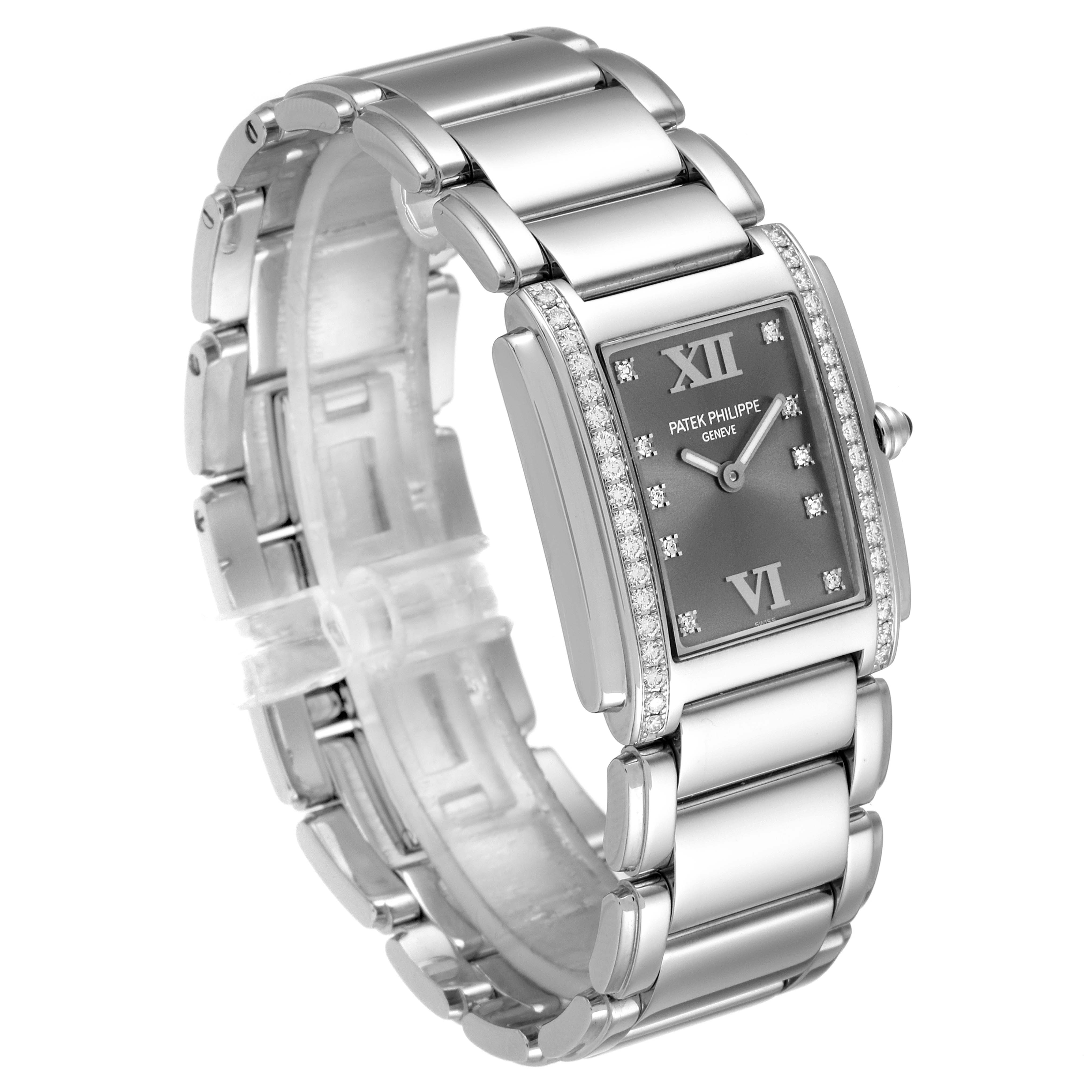 The image shows a silver Patek Philippe Twenty-4 4910/10A-010 Women's Stainless Steel Grey Dial 4910/10A-010 Women's Stainless Steel Grey Dial watch angled to highlight the bracelet and the diamond-studded rectangular dial.