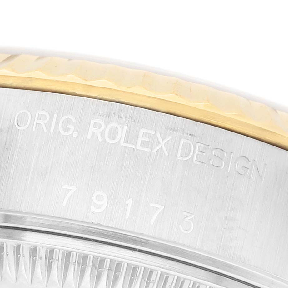 The image shows a close-up of the side of the Rolex Datejust 79173 Women's Steel and Gold (two tone) White Dial, displaying the model number and "ORIG. ROLEX DESIGN" engraving.