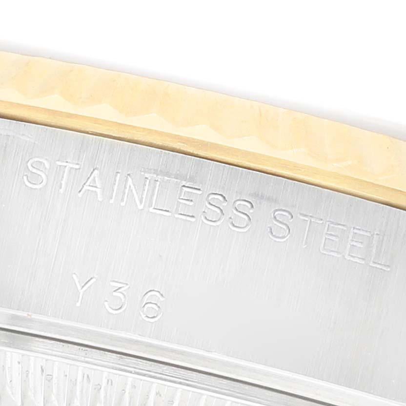The image shows a close-up of the stainless steel casing with engravings on the Rolex Datejust 79173 Women's Steel and Gold (two tone) White Dial, highlighting the material and serial number.