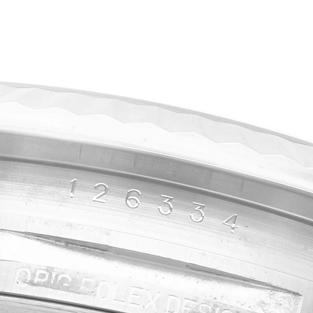 The image focuses on the engraved serial number on the inner bezel of the Rolex Datejust 41 126334 Men's Stainless Steel Blue Dial.