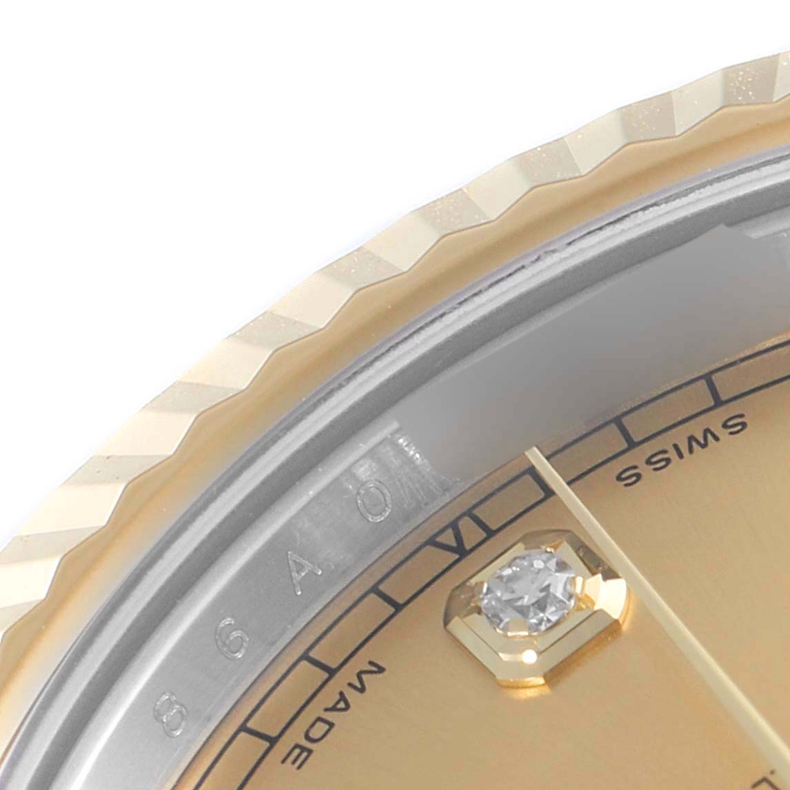 This close-up image of a Rolex Datejust 41 116333 Men's Steel and Gold (two tone) Champagne Dial 116333 Men's Steel and Gold (two tone) Champagne Dial watch shows a portion of the gold dial, a diamond marker, and the fluted bezel.