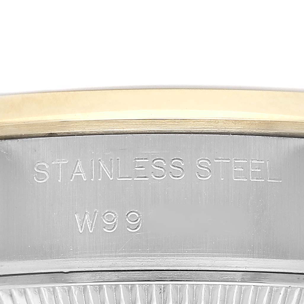 The image shows a close-up of the side of a Rolex Datejust 69163 Women's Steel and Gold (two tone) Champagne Dial watch, focusing on the stainless steel and gold bezel with etched markings.