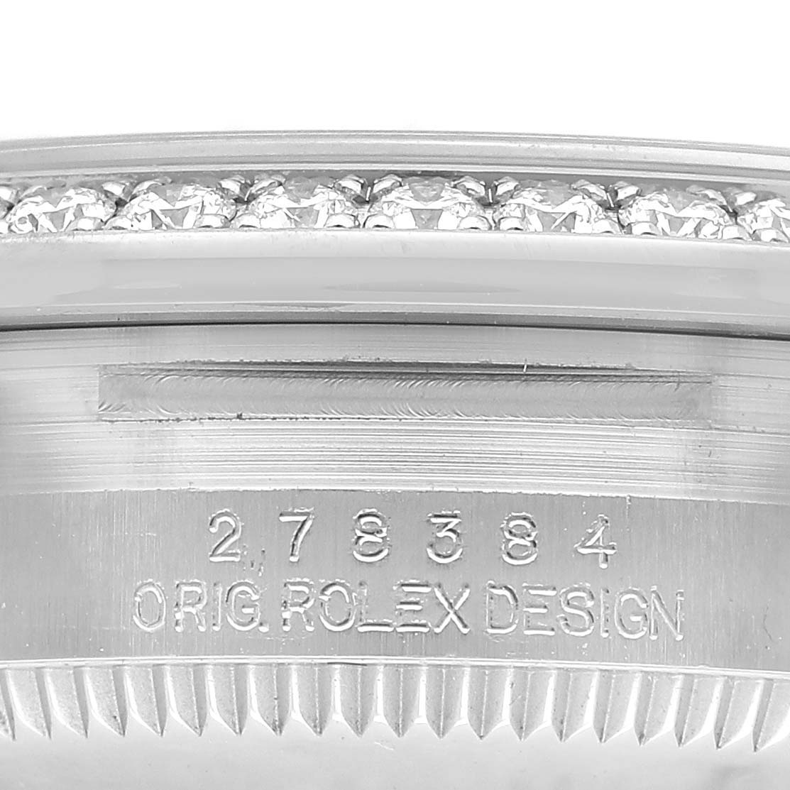 The image shows the side view of a Rolex Datejust 278384RBR Women's Stainless Steel Silver Dial's bezel with diamonds and part of its serial number engraving.