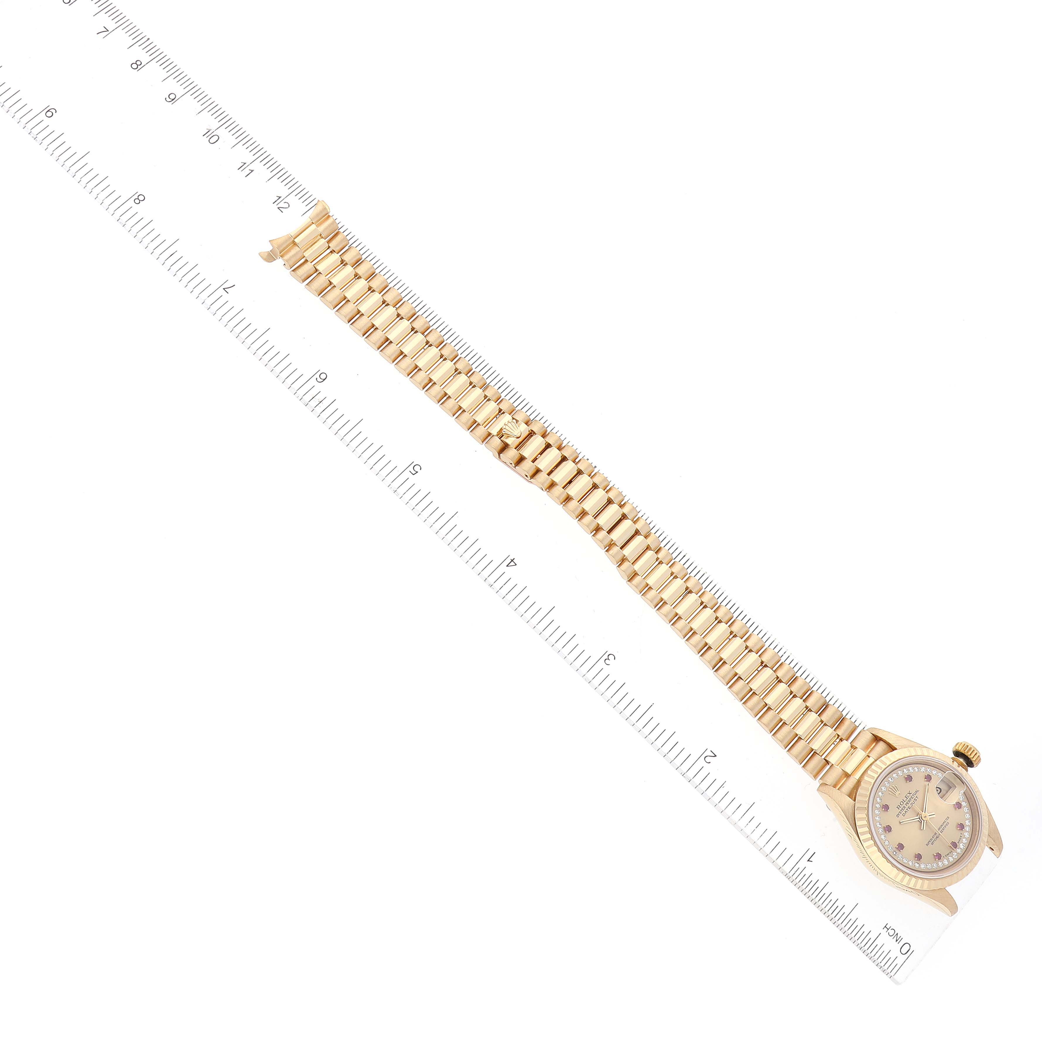 The image shows a top-down view of a Rolex President 69178 Women's Yellow Gold Champagne Dial 69178 Women's Yellow Gold Champagne Dial model watch laid next to a ruler for scale.