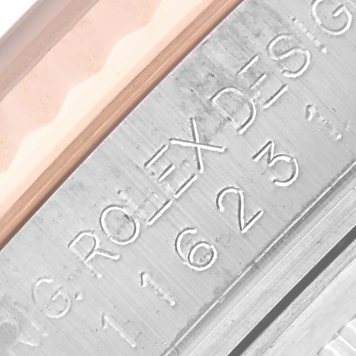 The image shows a close-up of the serial engraving on the side of a Rolex Datejust 116231 Men's Steel and Gold (two tone) Pink Dial 116231 Men's Steel and Gold (two tone) Pink Dial watch case.