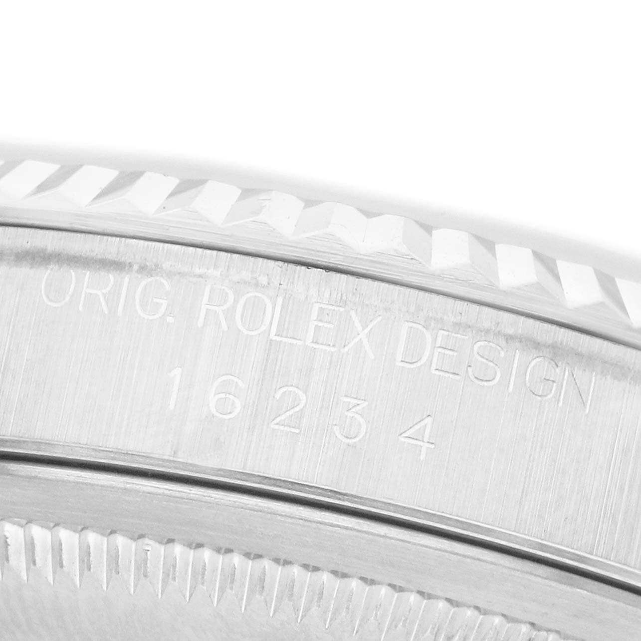 The image shows a close-up of the side engraving and bezel of a Rolex Datejust 16234 Men's White Gold Silver Dial watch.