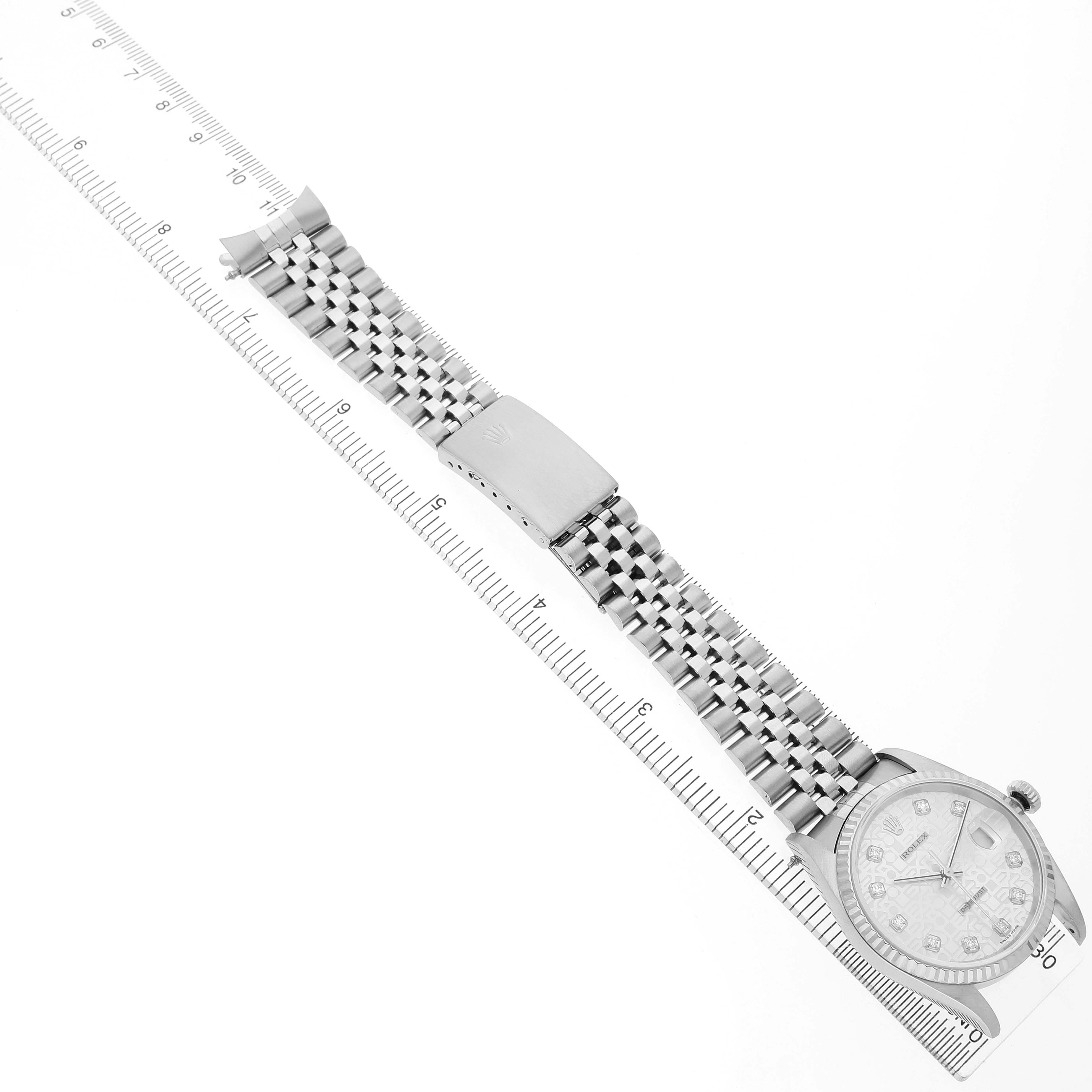 The image shows the Rolex Datejust 16234 Men's White Gold Silver Dial watch from an overhead angle, highlighting the full bracelet and clasp on a scale.