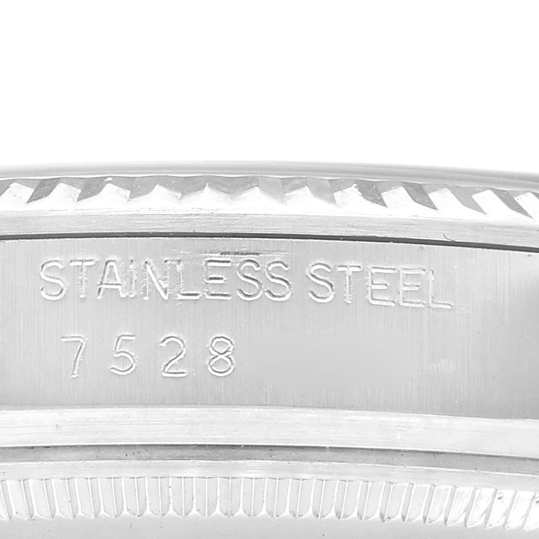 This close-up image shows the etched stainless steel case back of the Vintage Collection model by Rolex, highlighting its model number, 7528.