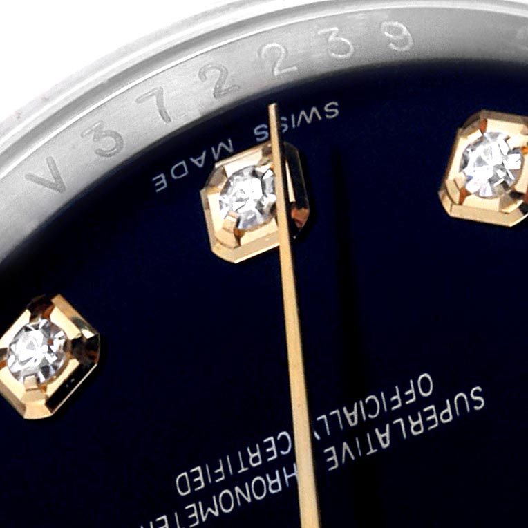 The image shows a close-up angle of a Rolex Datejust 116233 Men's Steel and Gold (two tone) Black Dial 116233 Men's Steel and Gold (two tone) Black Dial watch dial, focusing on diamond hour markers and part of the bezel with engraving.