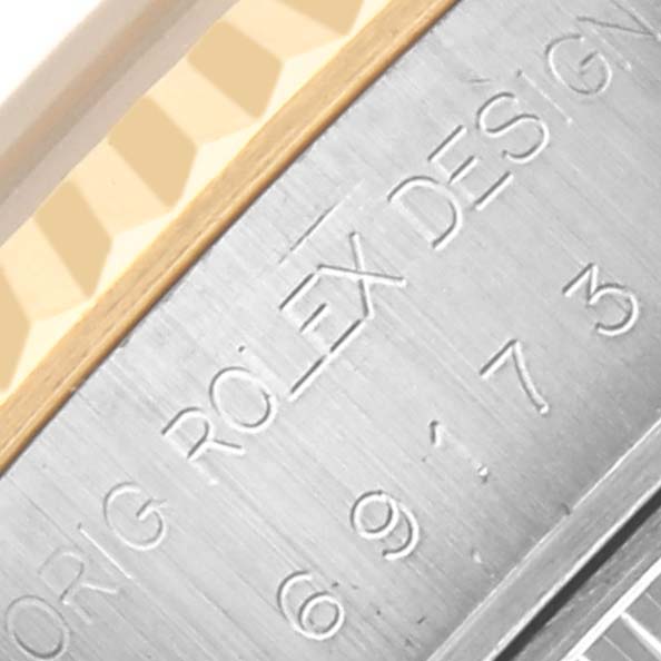 The image shows a close-up of the side of a Rolex Datejust 69173 Women's Steel and Gold (two tone) Champagne Dial 69173 Women's Steel and Gold (two tone) Champagne Dial, highlighting the engraved text and fluted bezel detail.